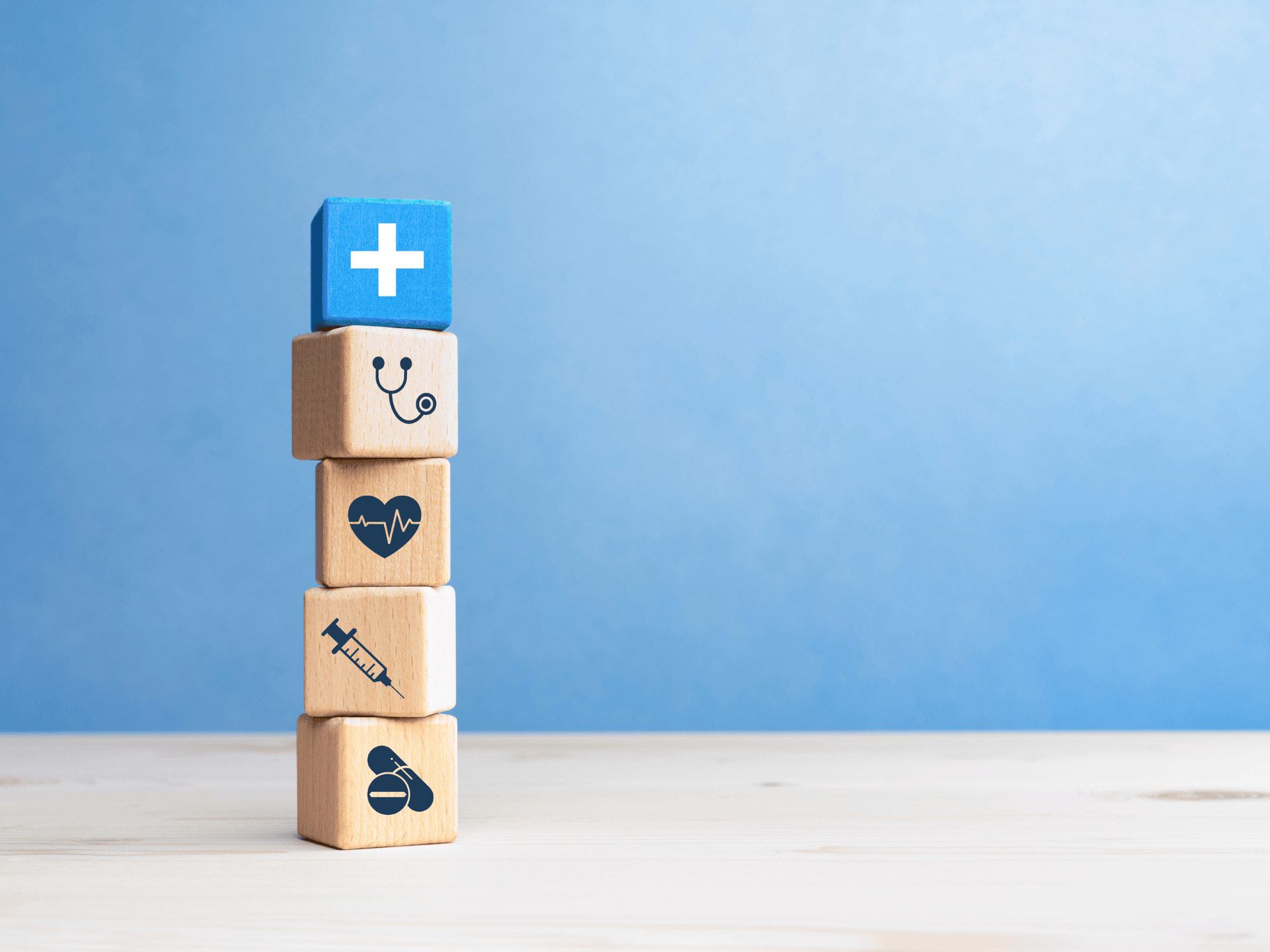Health insurance concept, wooden blocks with healthcare medical icons on blue background