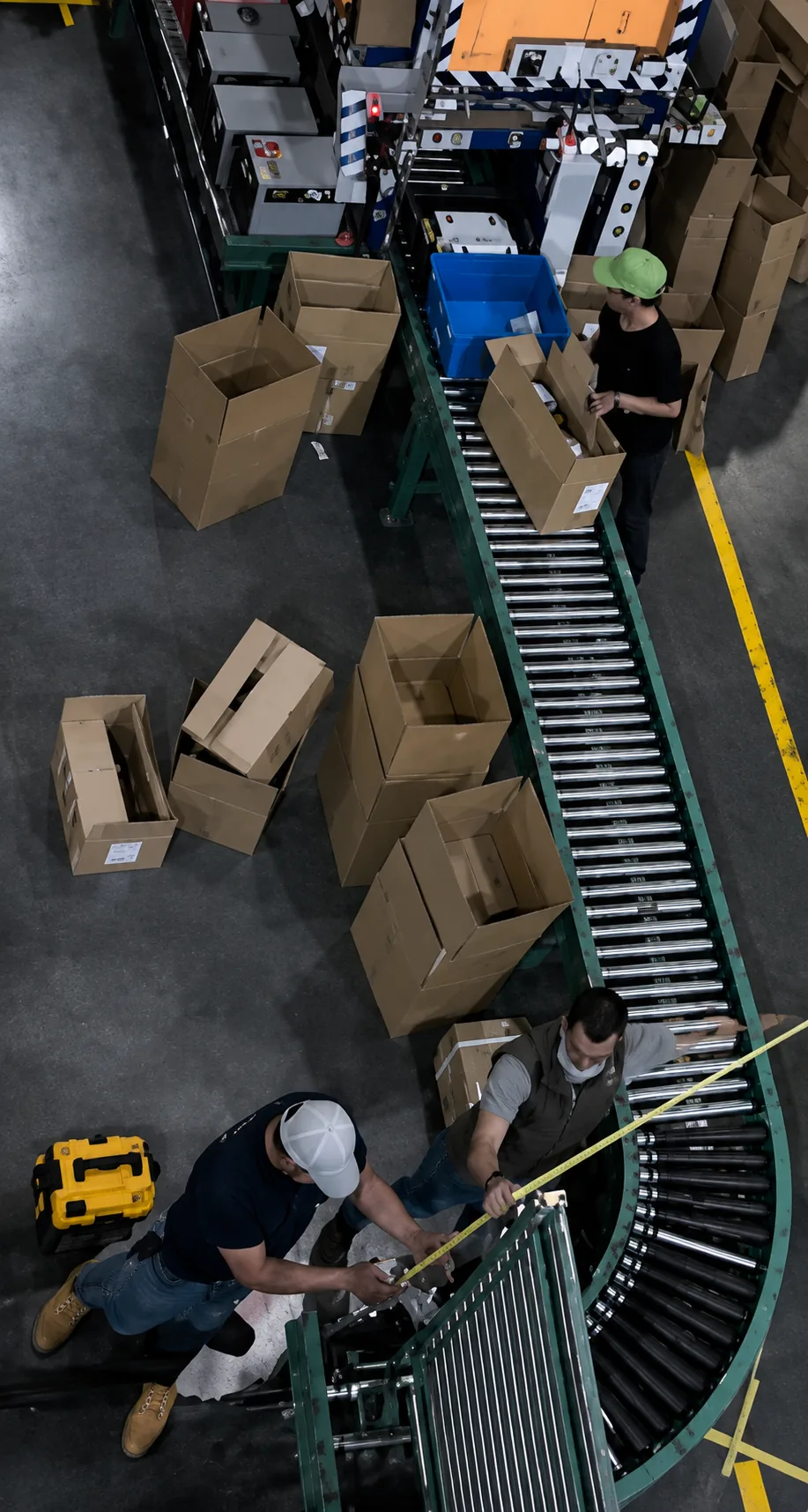 Top-down view of workers handling boxes at a conveyor