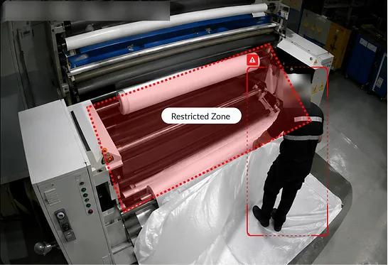 Worker next to a press, with the restricted zone marked in red