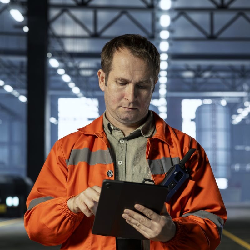 A shift lead on the factory floor checking a tablet on the factory floor