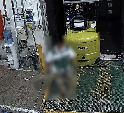 Dock worker with the whole body blurred next to a forklift