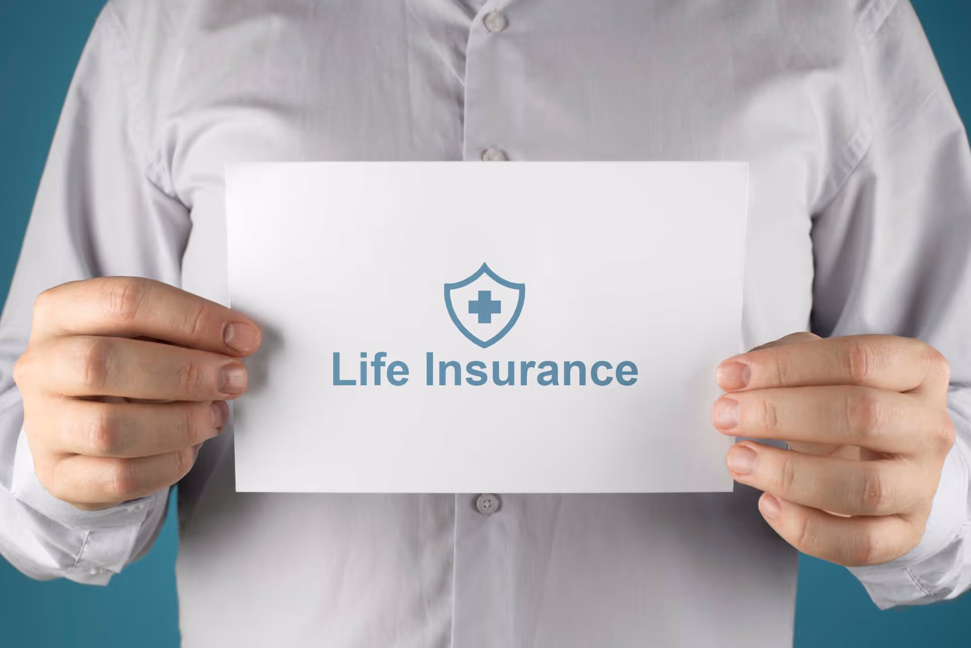 Person holds a paper with "Life Insurance" text and a shield symbol.