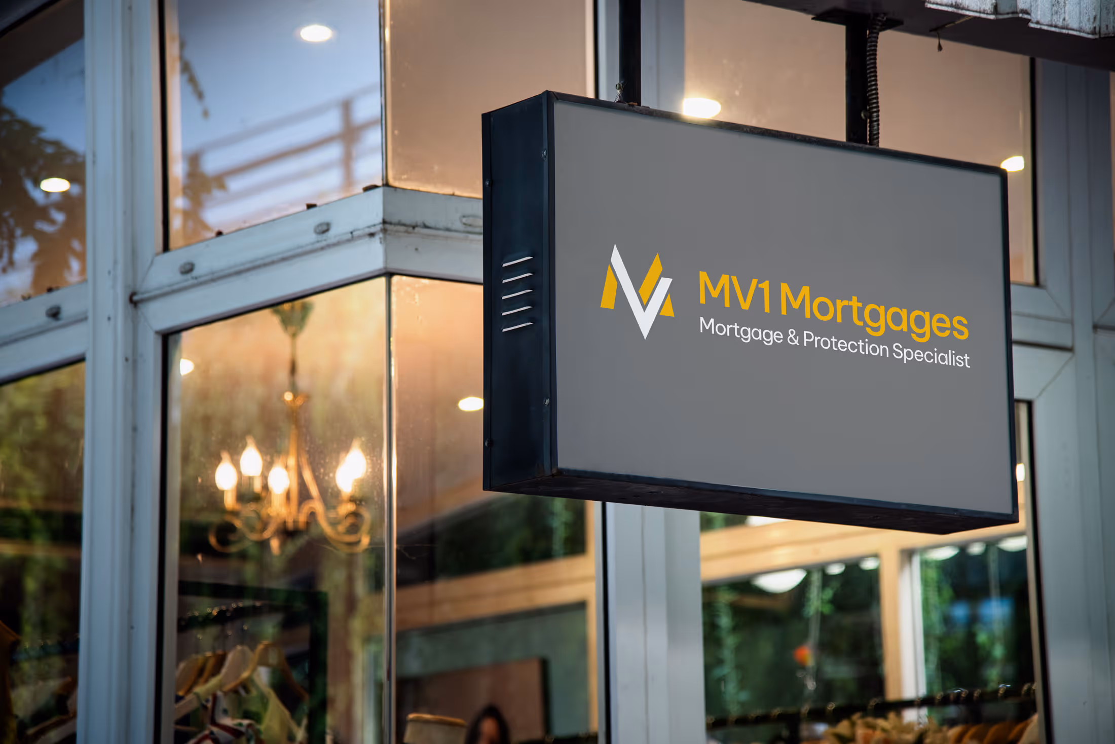 Sign for "MV1 Mortgages" on a building corner, advertising mortgage and protection specialist services.
