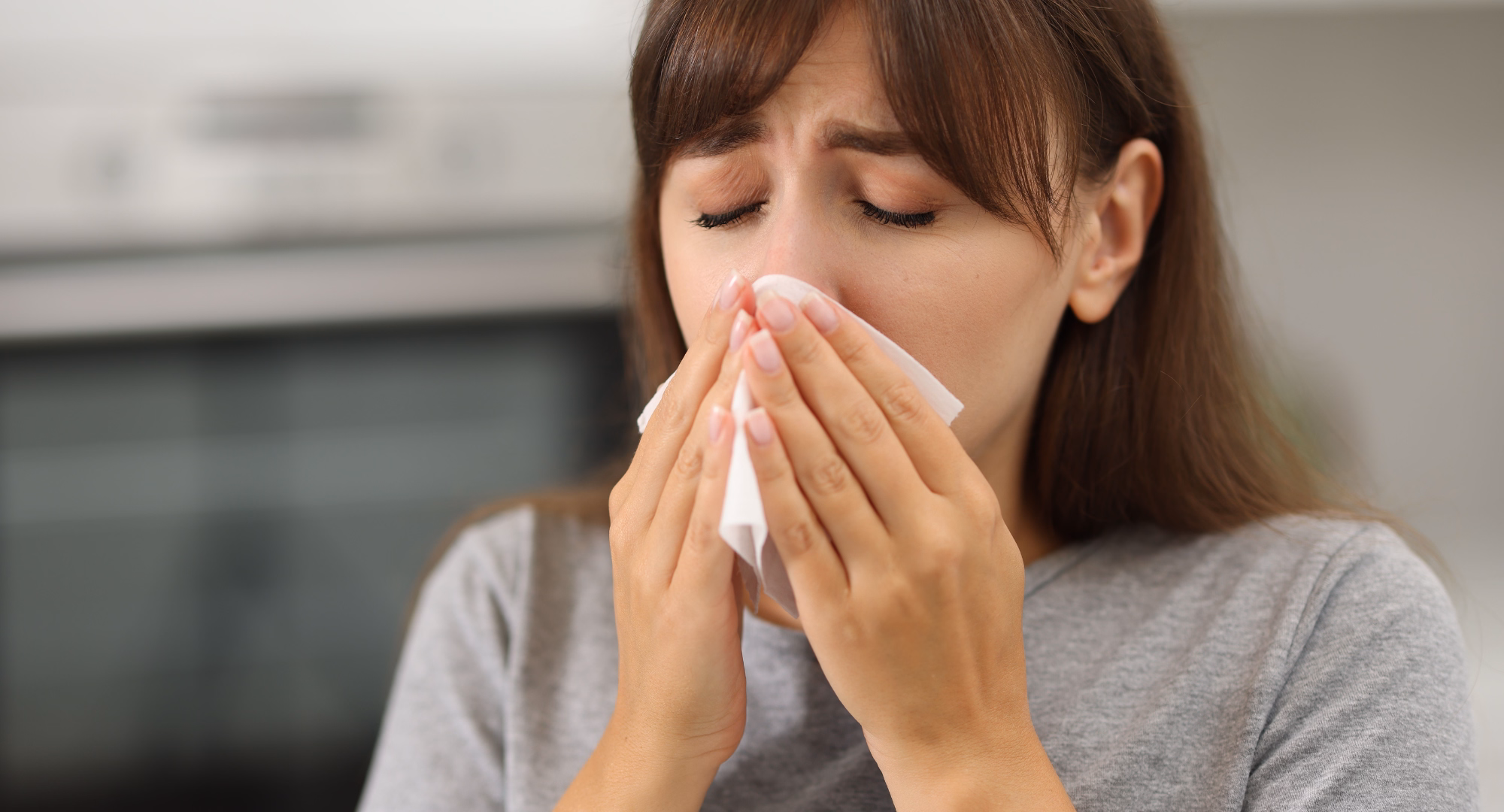 Žena drži maramicu na nosu jer ima sinusitis
