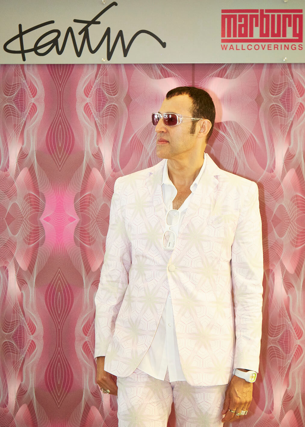 Karim Rashid in front of a retro wallpaper.