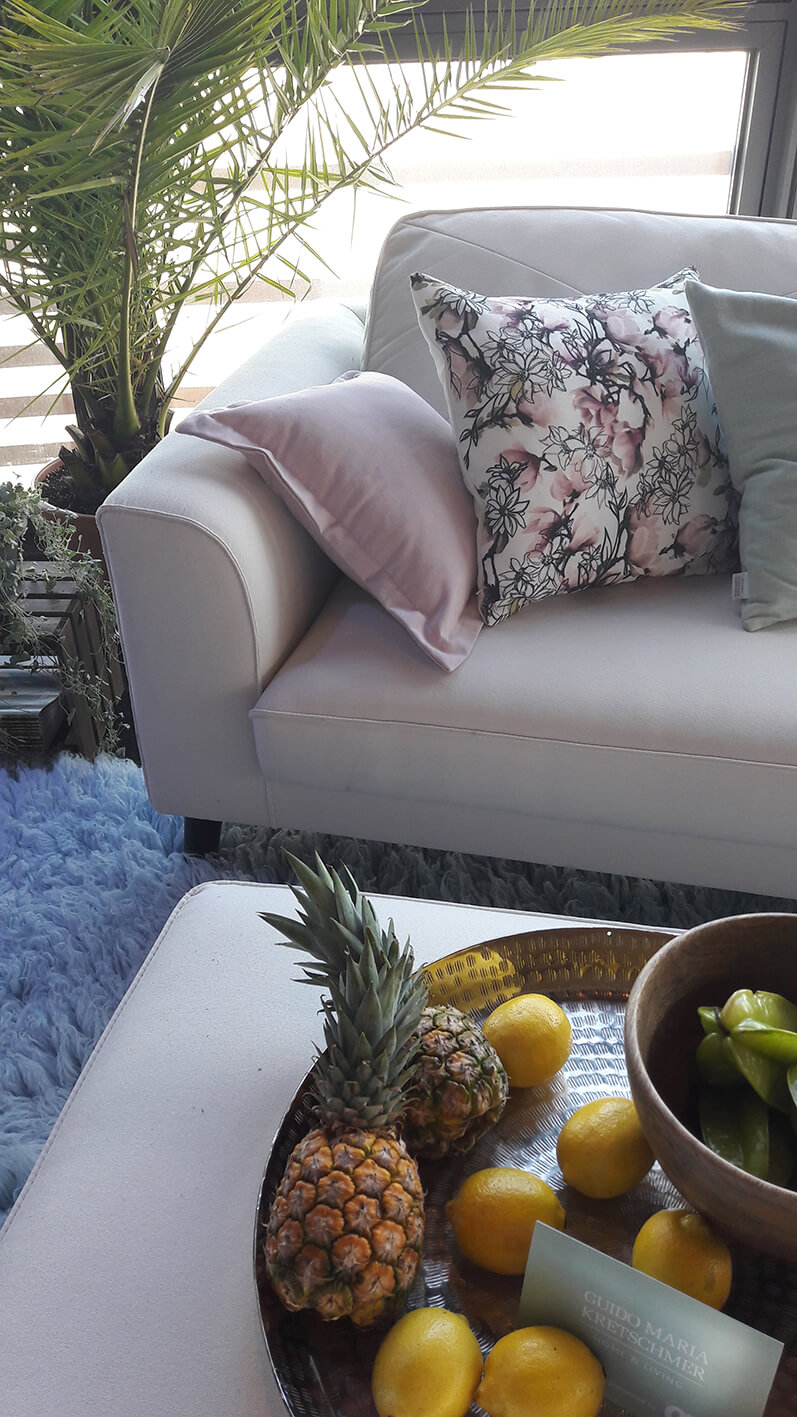 A bowl of fruits in front of a couch.