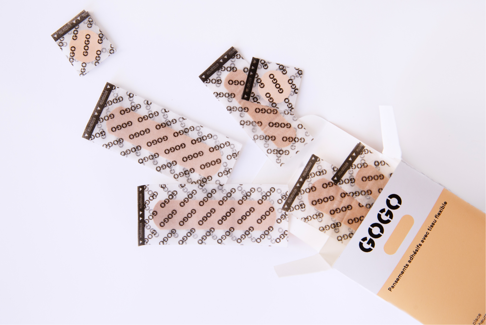 Band-aid packaging opened up with band-aids scattered around it