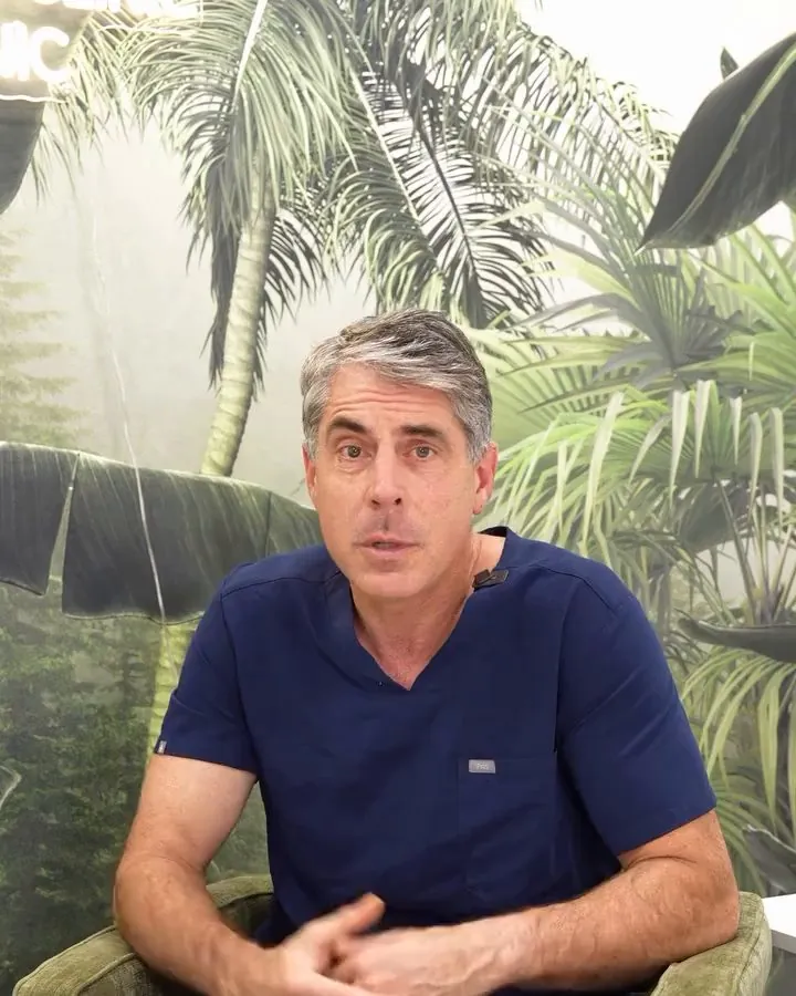 Dr. Buonassisi seated in front of a palm wall, answering a question
