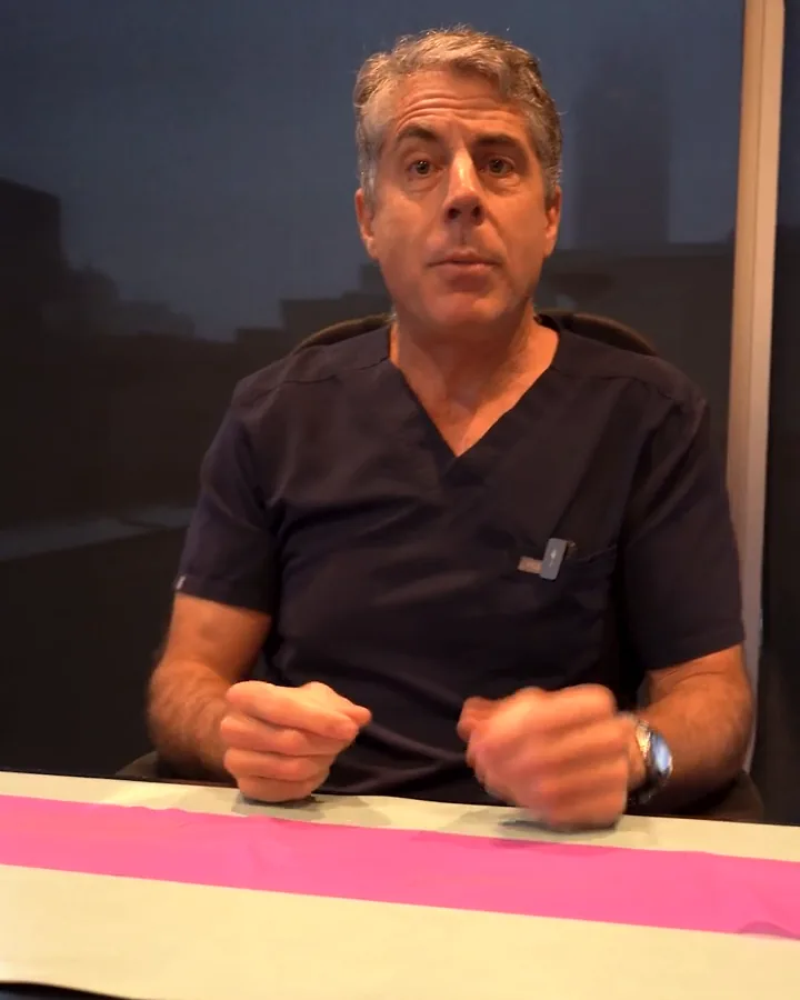 Dr. Buonassisi at his desk, explaining the layers of the face with two strips of material