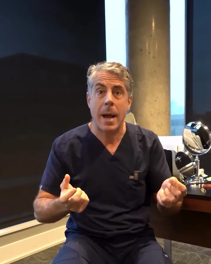 Dr. Buonassisi seated in his office, explaining neck skin with an exercise band