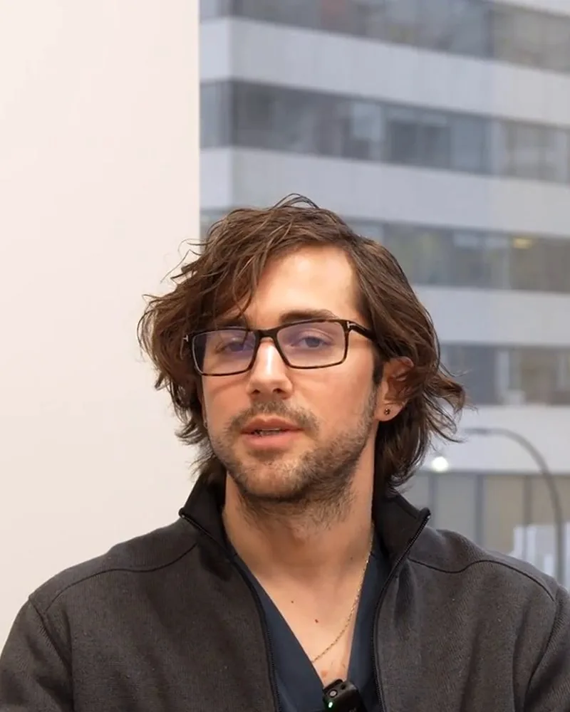 Dr. Masschelein seated in his office, explaining with both hands