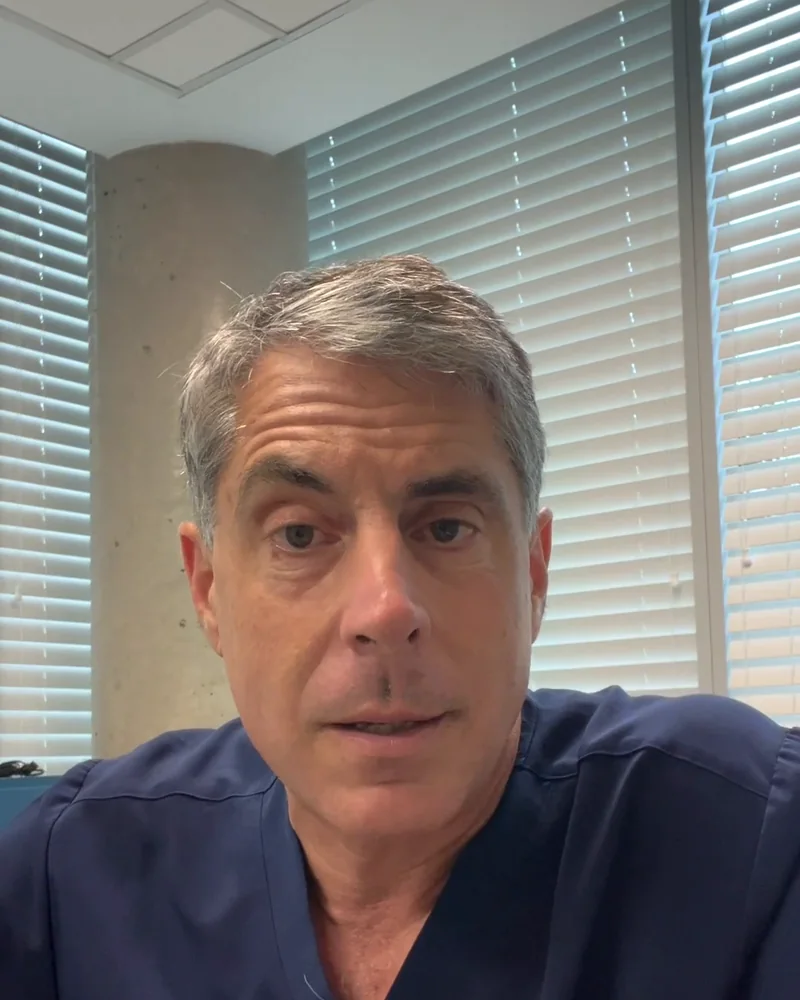 Dr. Buonassisi in surgical scrubs, answering a question