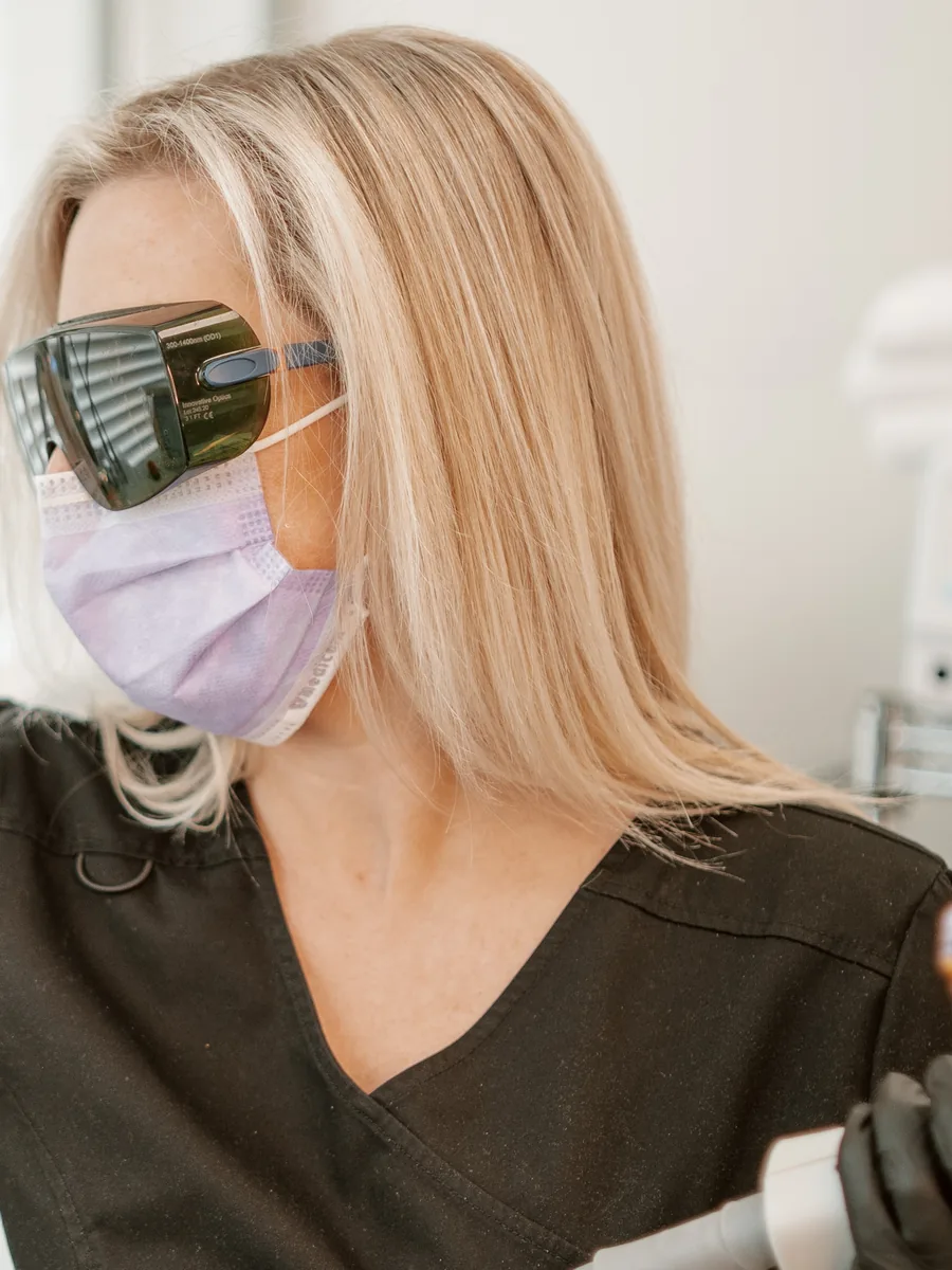 Suzanne Power in laser safety glasses in a treatment room