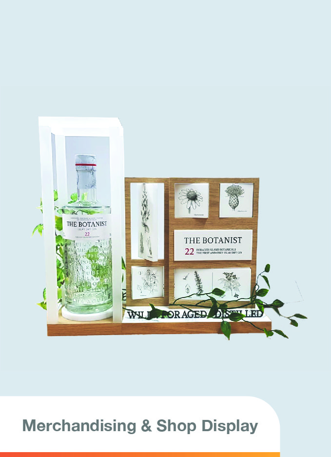 presents a clear gin bottle embellished with small green leaves, encased within a frosted frame. Adjacent to it stands a medium-sized panel featuring a wood-like finish. This panel contains smaller white acrylic pieces with floral designs on the front and descriptions on the back. These pieces are reversible
