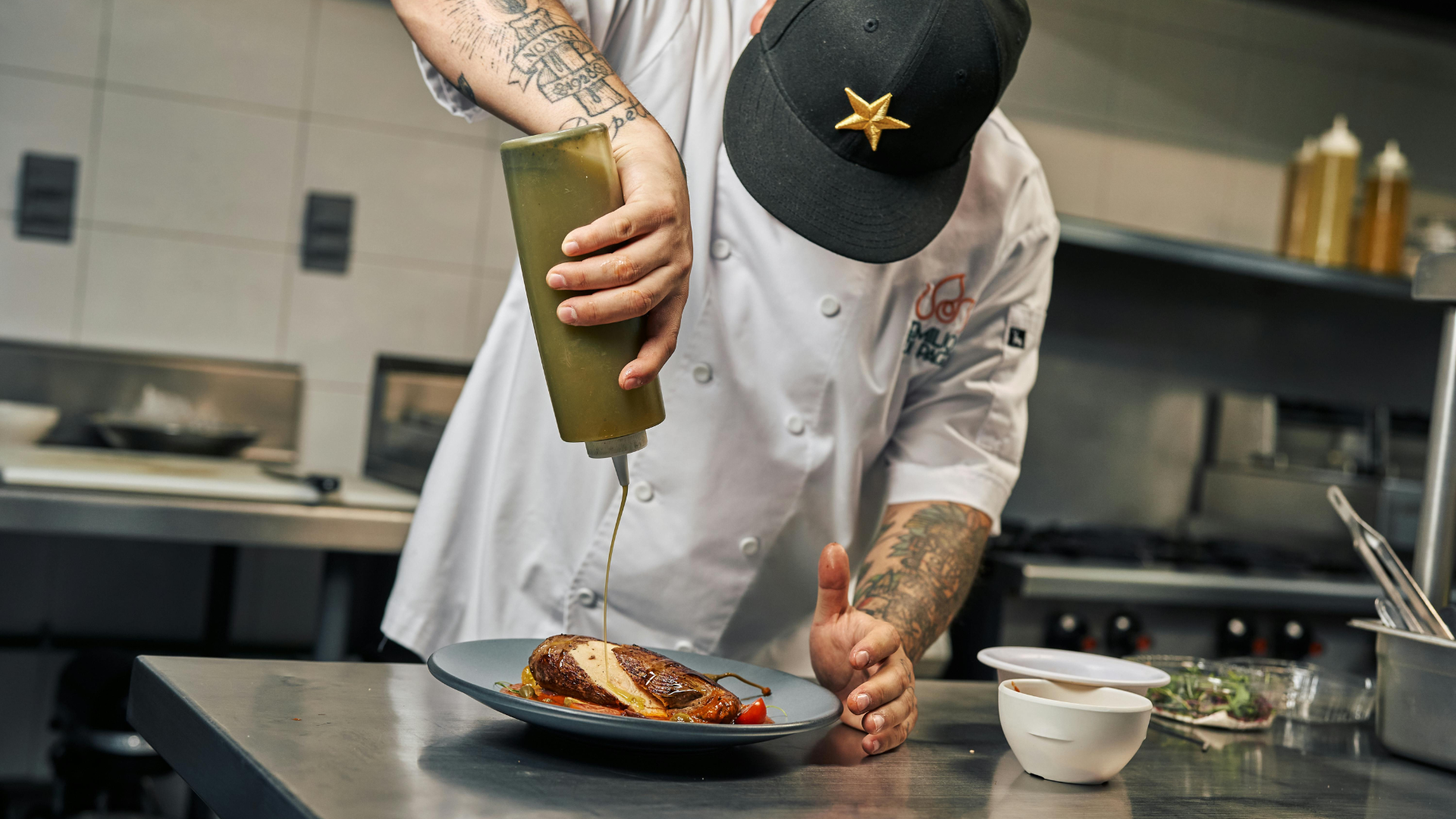 Chef preparing a dish in a professional restaurant kitchen workspace 