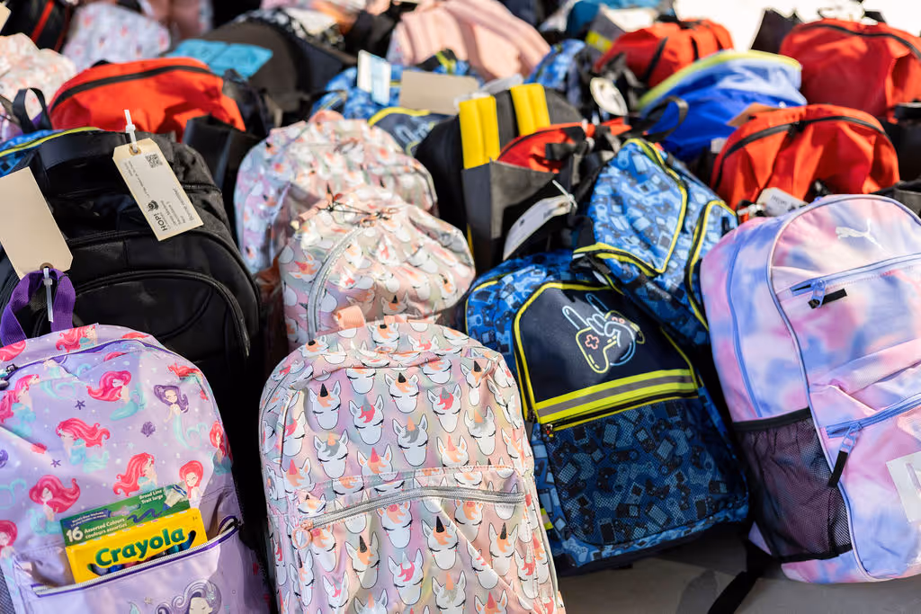a group of volunteers holding donation bags for a group picture