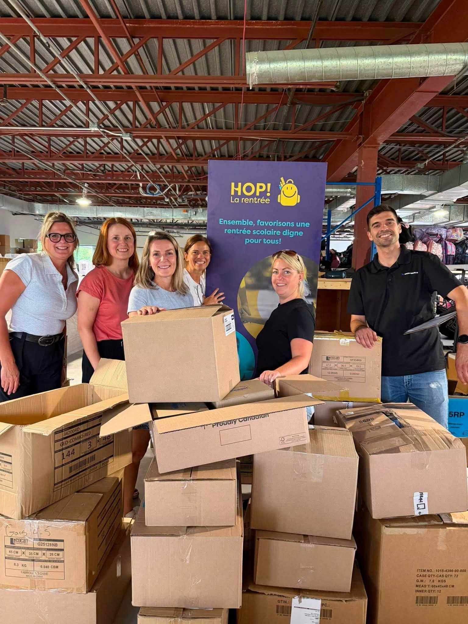 a group of volunteers holding donation bags for a group picture