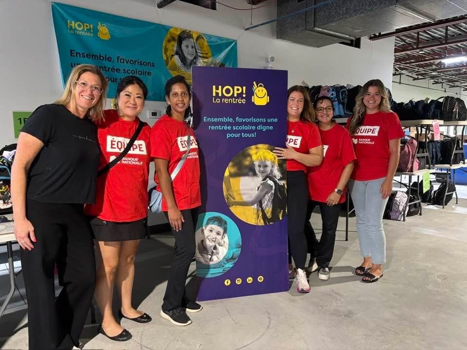 a group of volunteers holding donation bags for a group picture