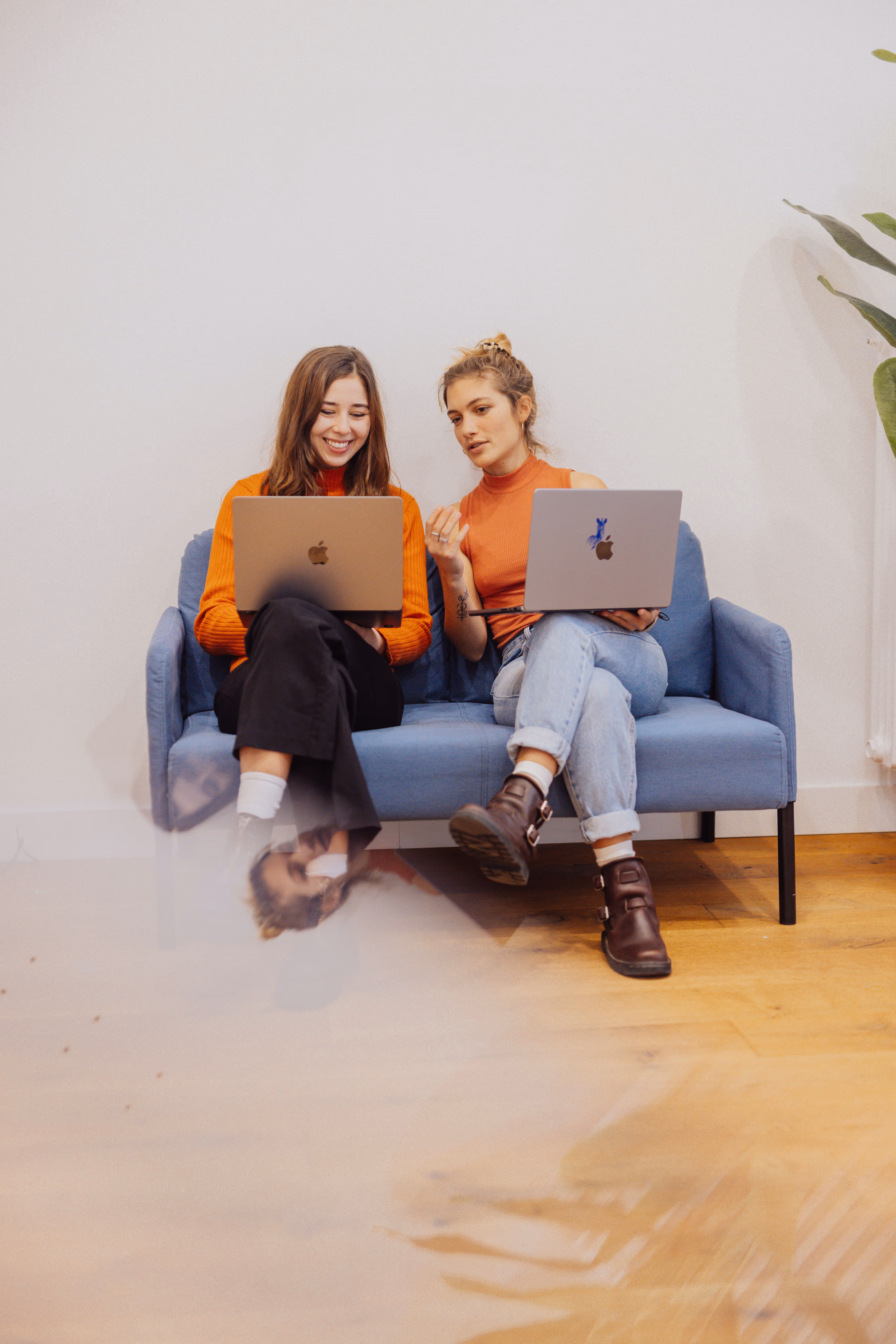 2 women looking at screens and discussing