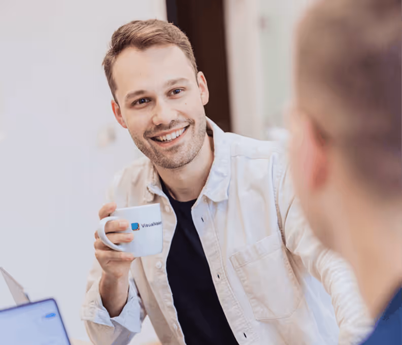 smiling team member with branded visualmakers cup in hand