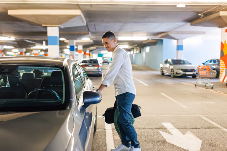 man opening car in a commercial parking garage