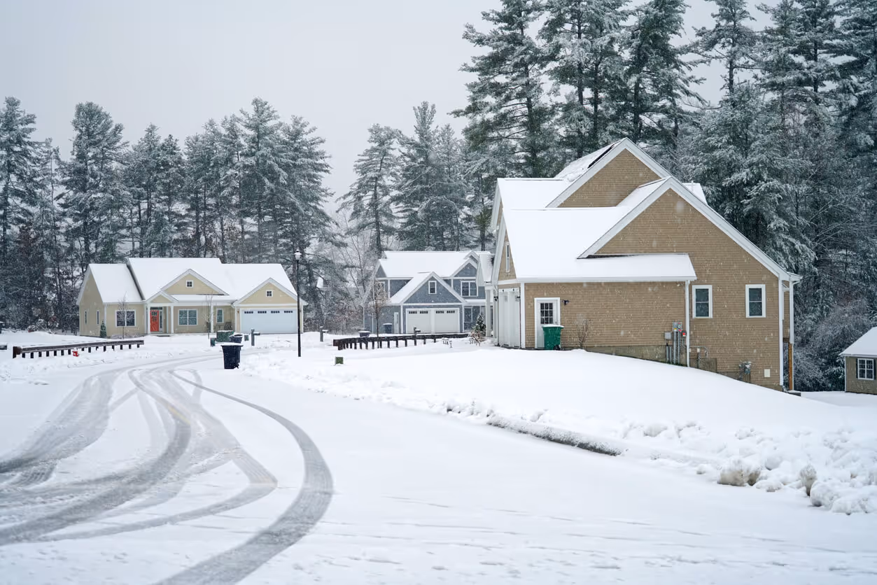 new hampshire home insurance coverage concept - houses on both sides of street in residential community after snow in winter
