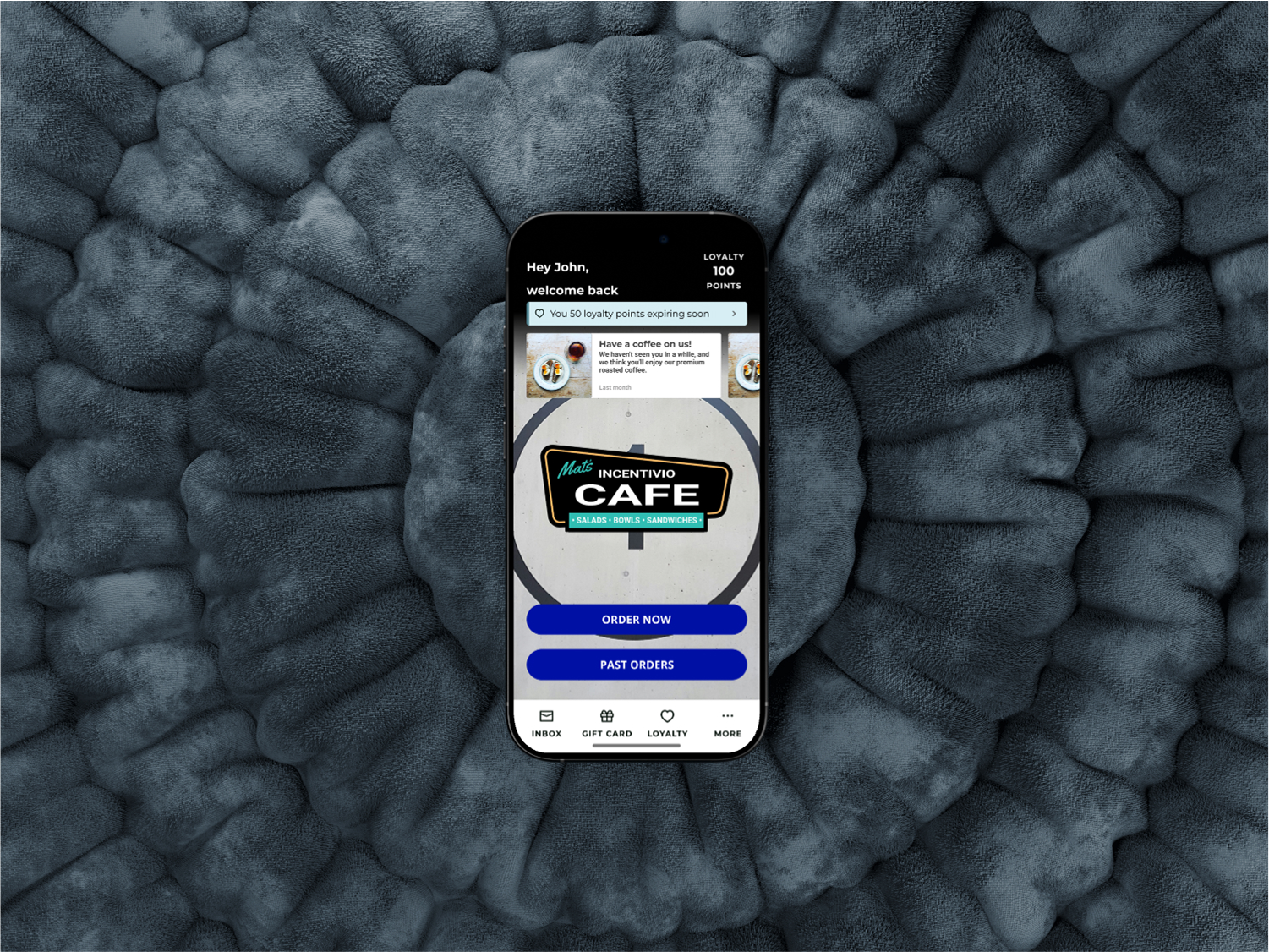 Phone with home screen of Incentivio app on a grayish textured circular background