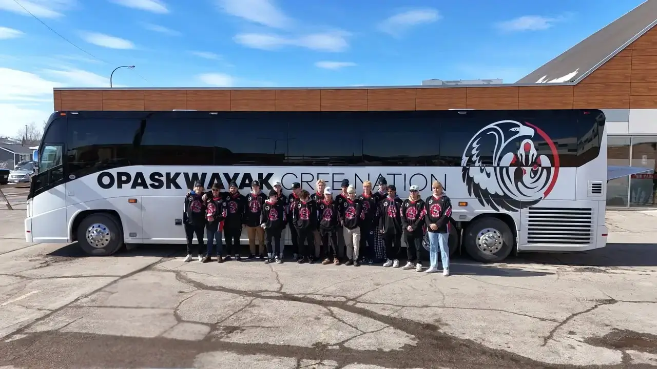 Opaskwayak Cree Nation team by their MCI J4500 motorcoach, providing reliable Indigenous community transport.
