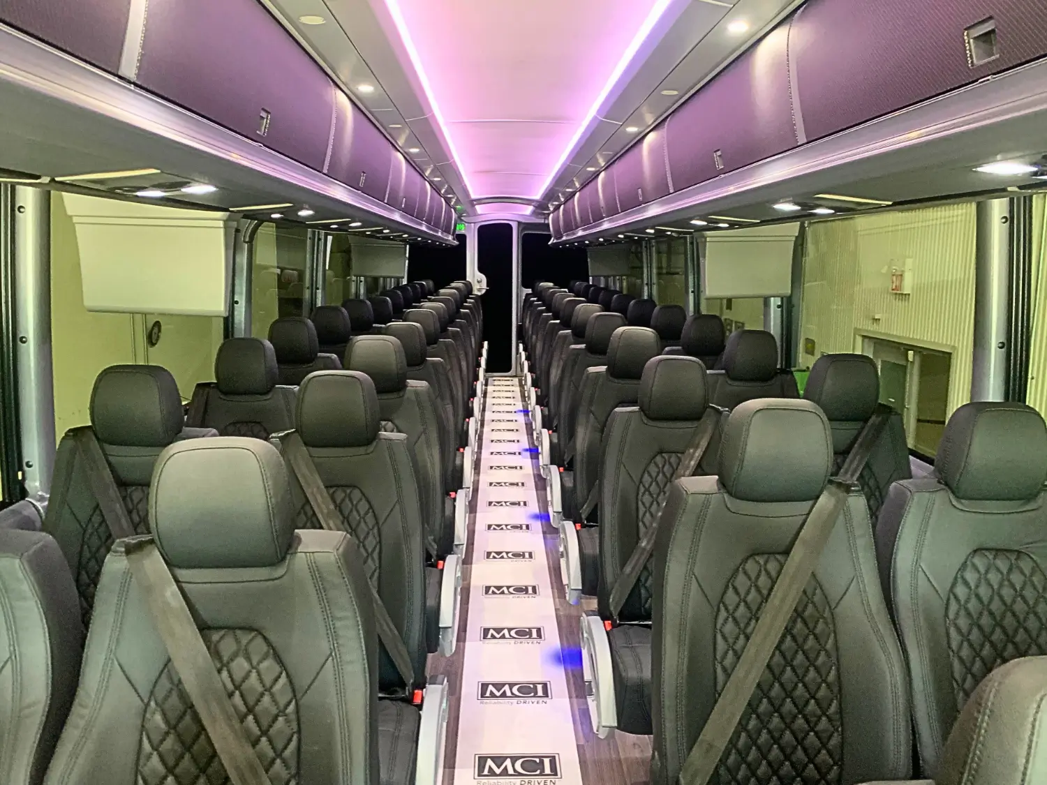 Interior of 2026 MCI J4500: Amaya Alpha seats with 3-point belts for passenger comfort & safety.