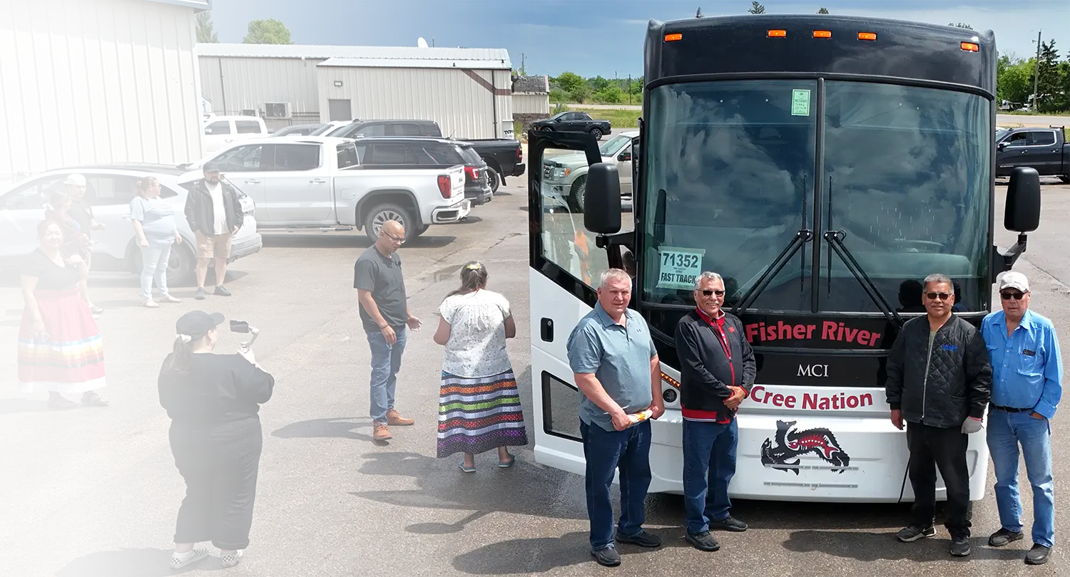 Fisher River Cree Nation community members standing in front of their new MCI motorcoach.
