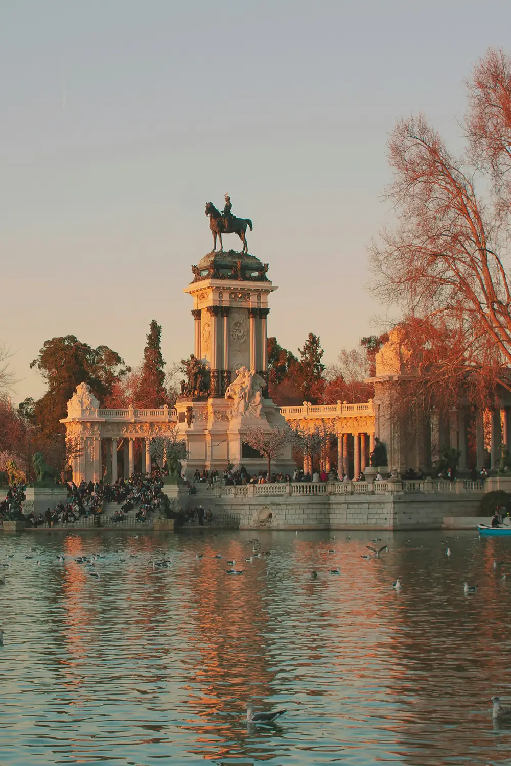 Modern home exterior with a large rectangular upper floor, a small tree in front, and a person walking in a shaded walkway.