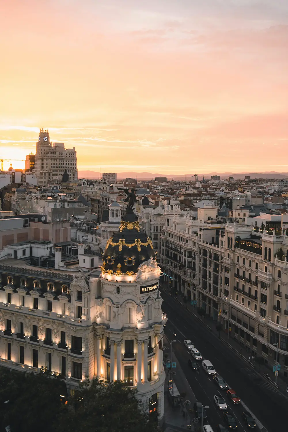 Minimalist bathroom corner with an oval mirror, wall-mounted faucet, and a round basin sink on a black metal stand over pebbled flooring.