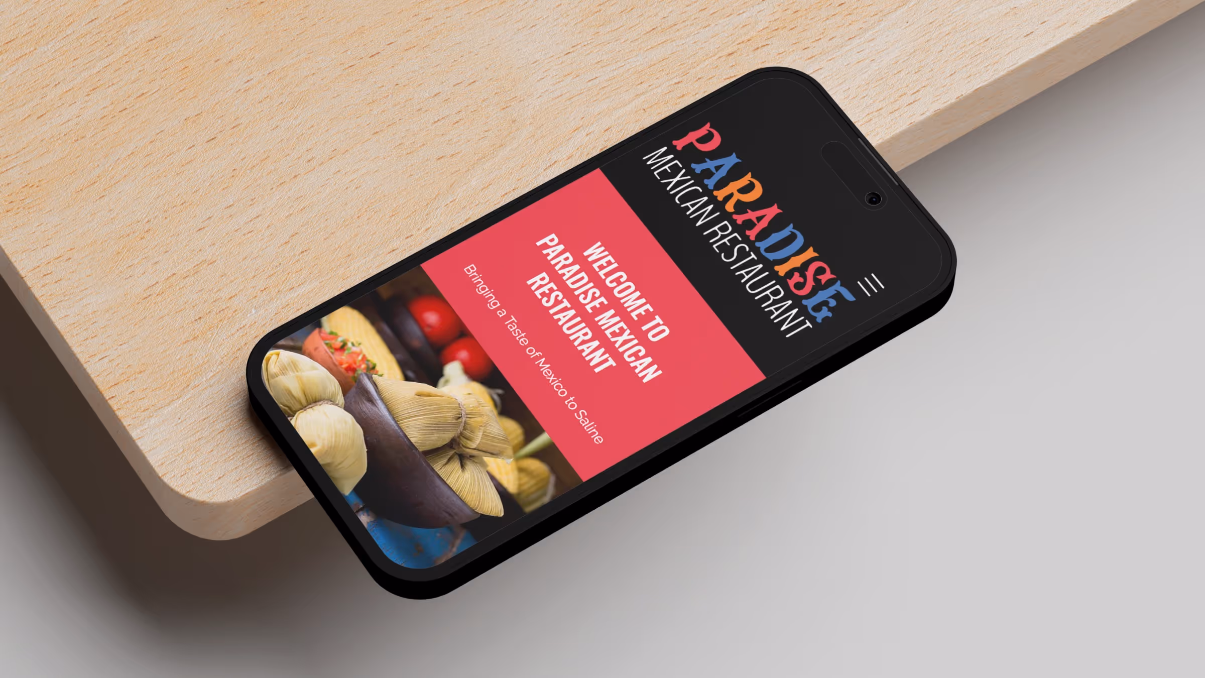 Paradise Mexican Restaurant landing page on iPhone placed on edge of table
