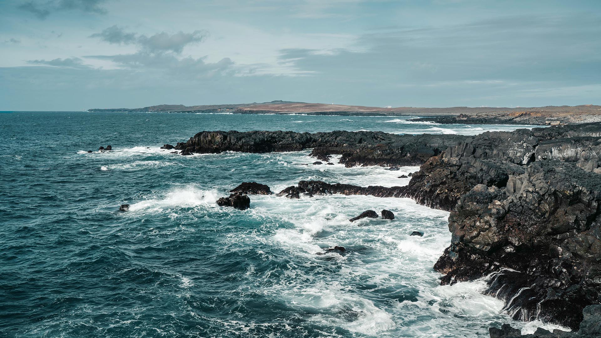 Waves crashing against coastal cliffs in Iceland.