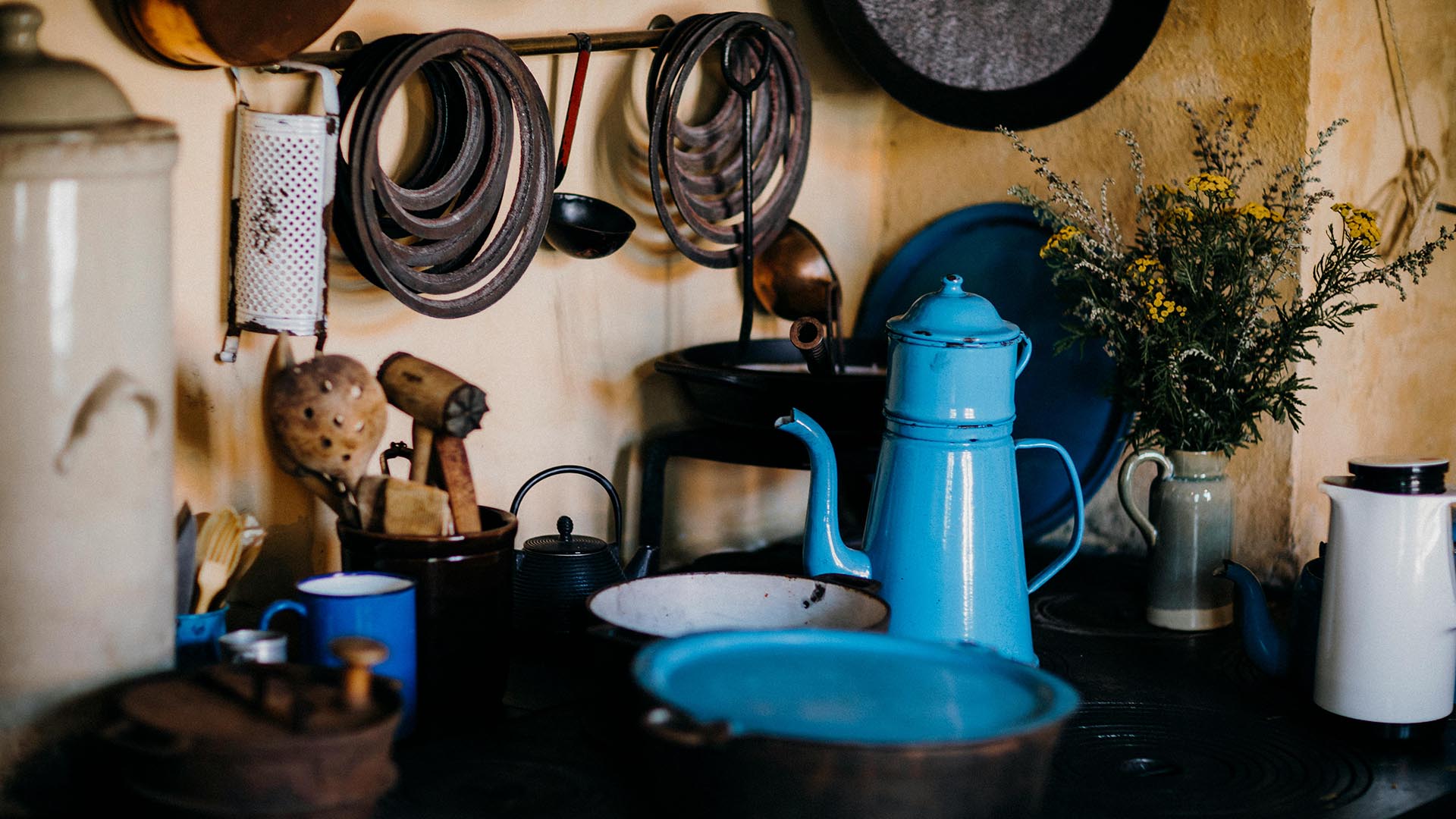Kettles, pots, and cookware in a rustic kitchen.