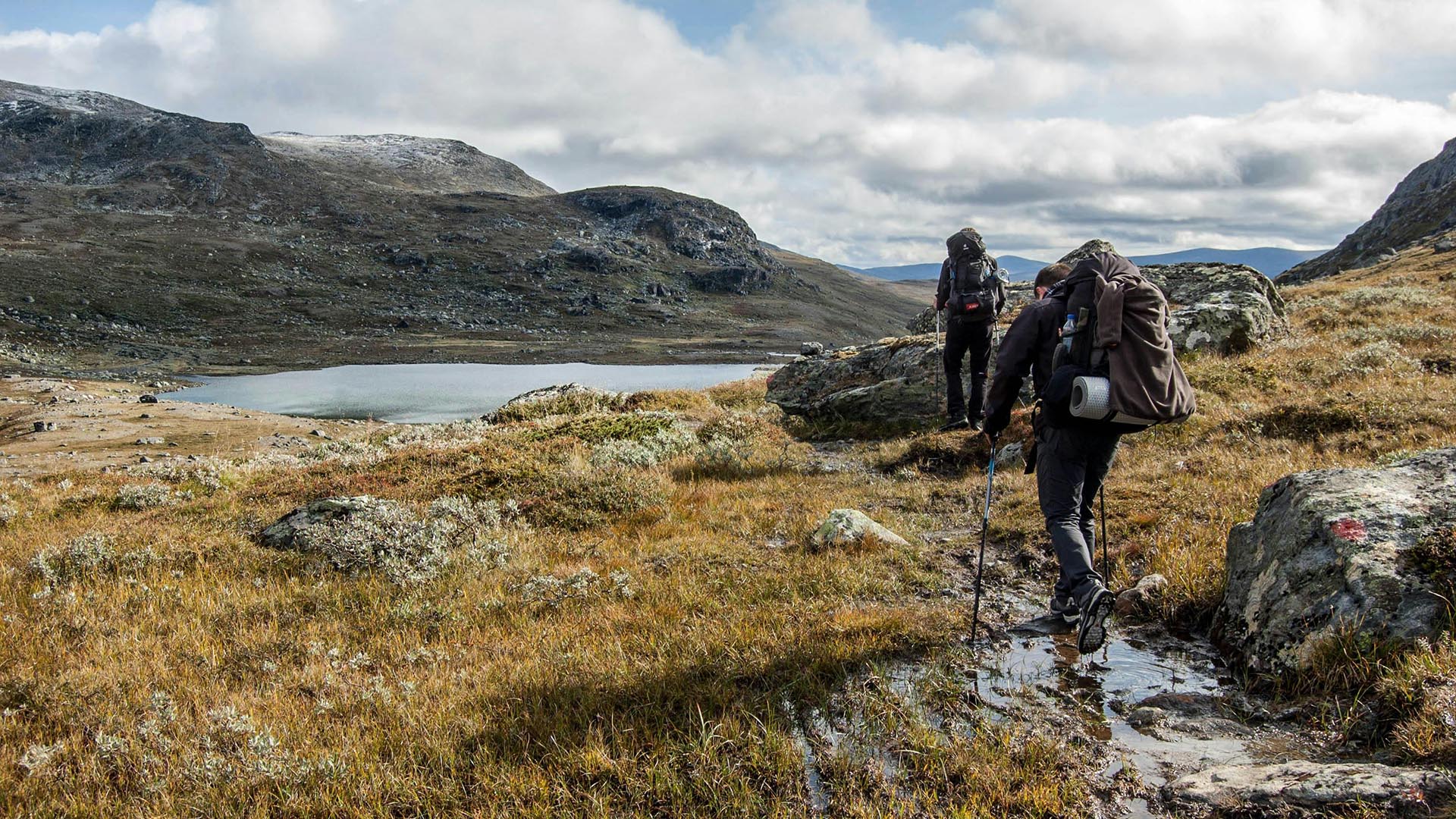Two hikers on a mountain path in Sweden.