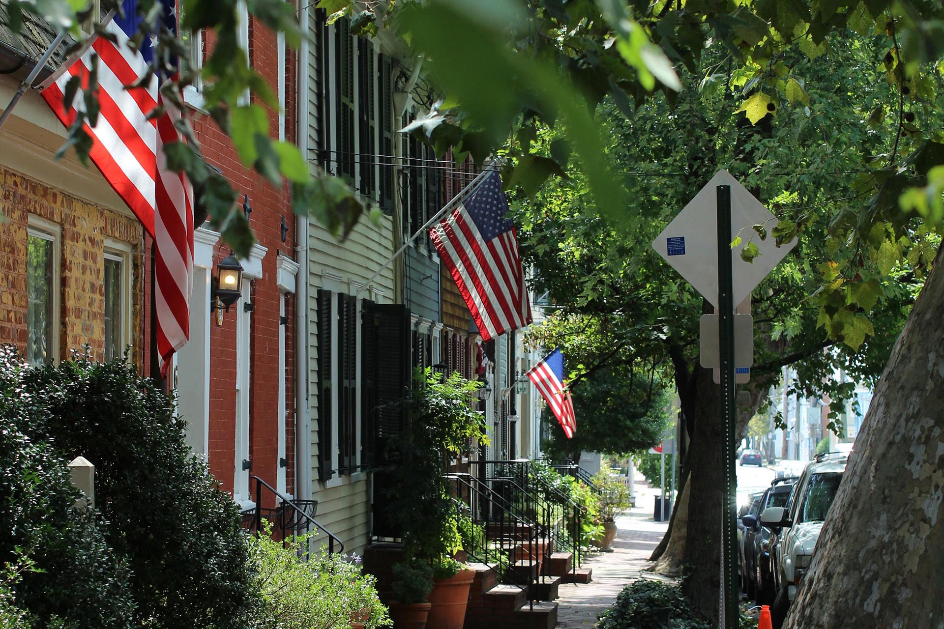 A photo of historic townhouses with American flags.