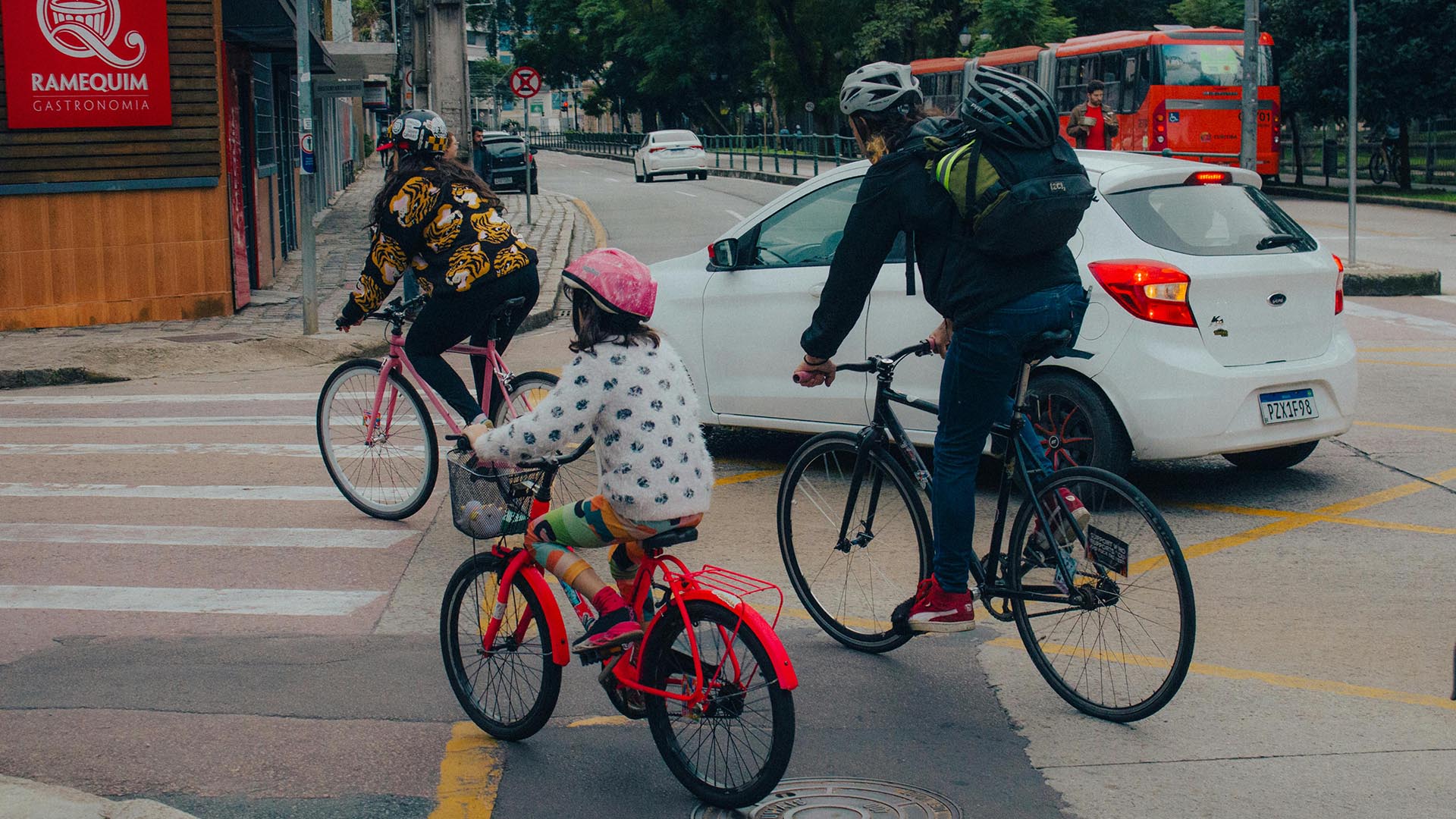 A young family riding bikes on a city street.