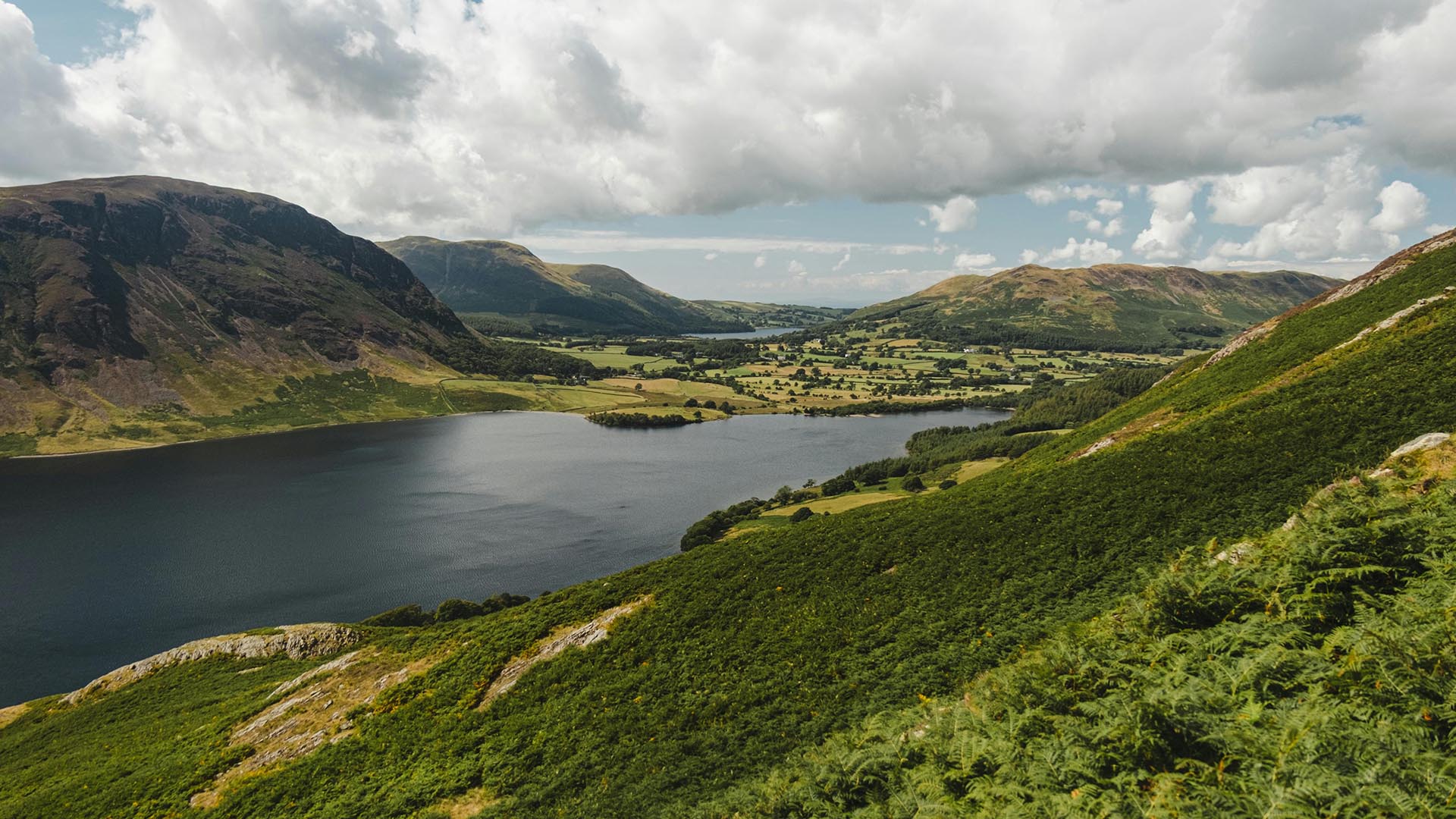 A photo of a lake between rolling hills and farmland.