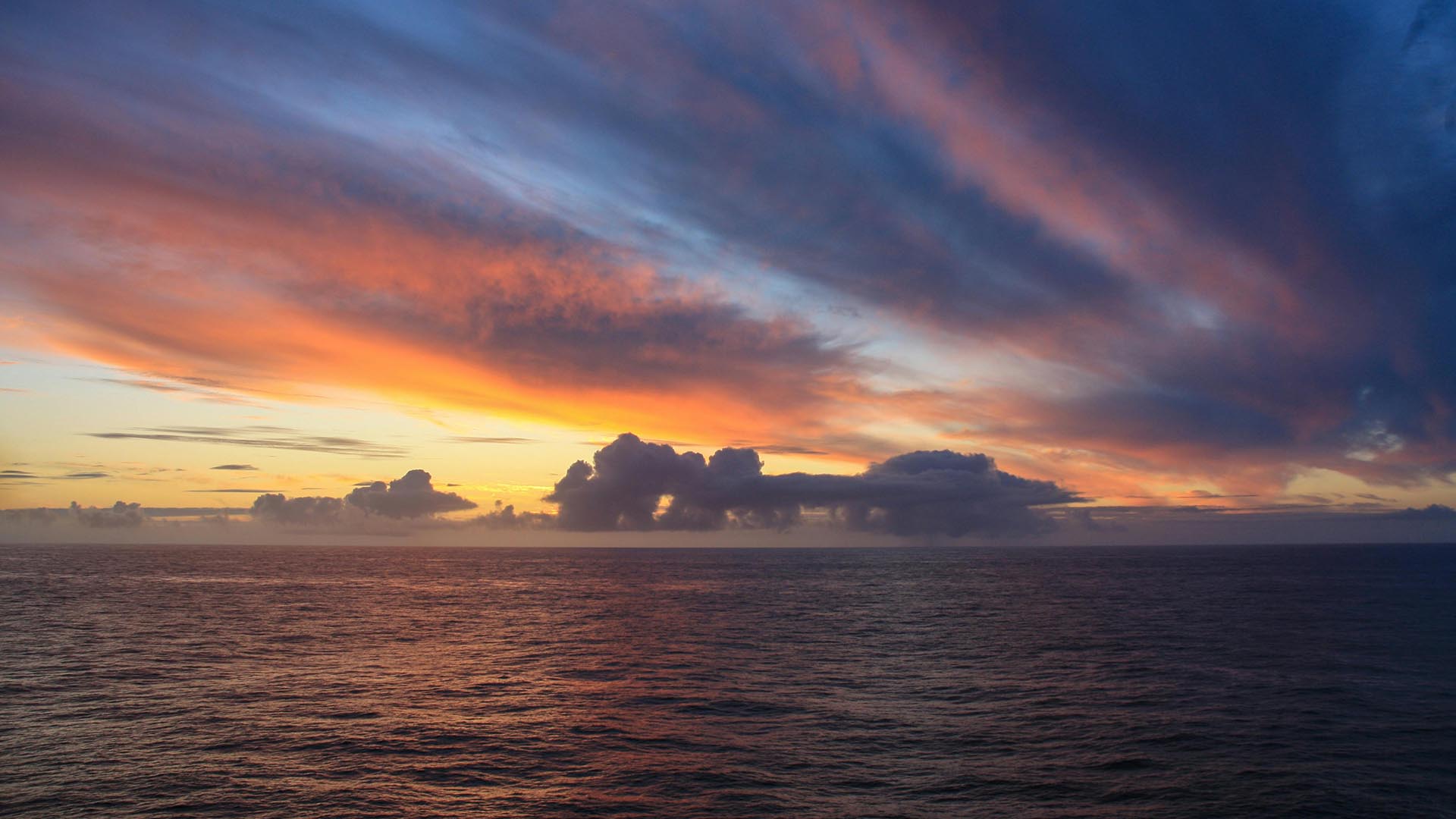 A photo of pink and orange sunset over the ocean.