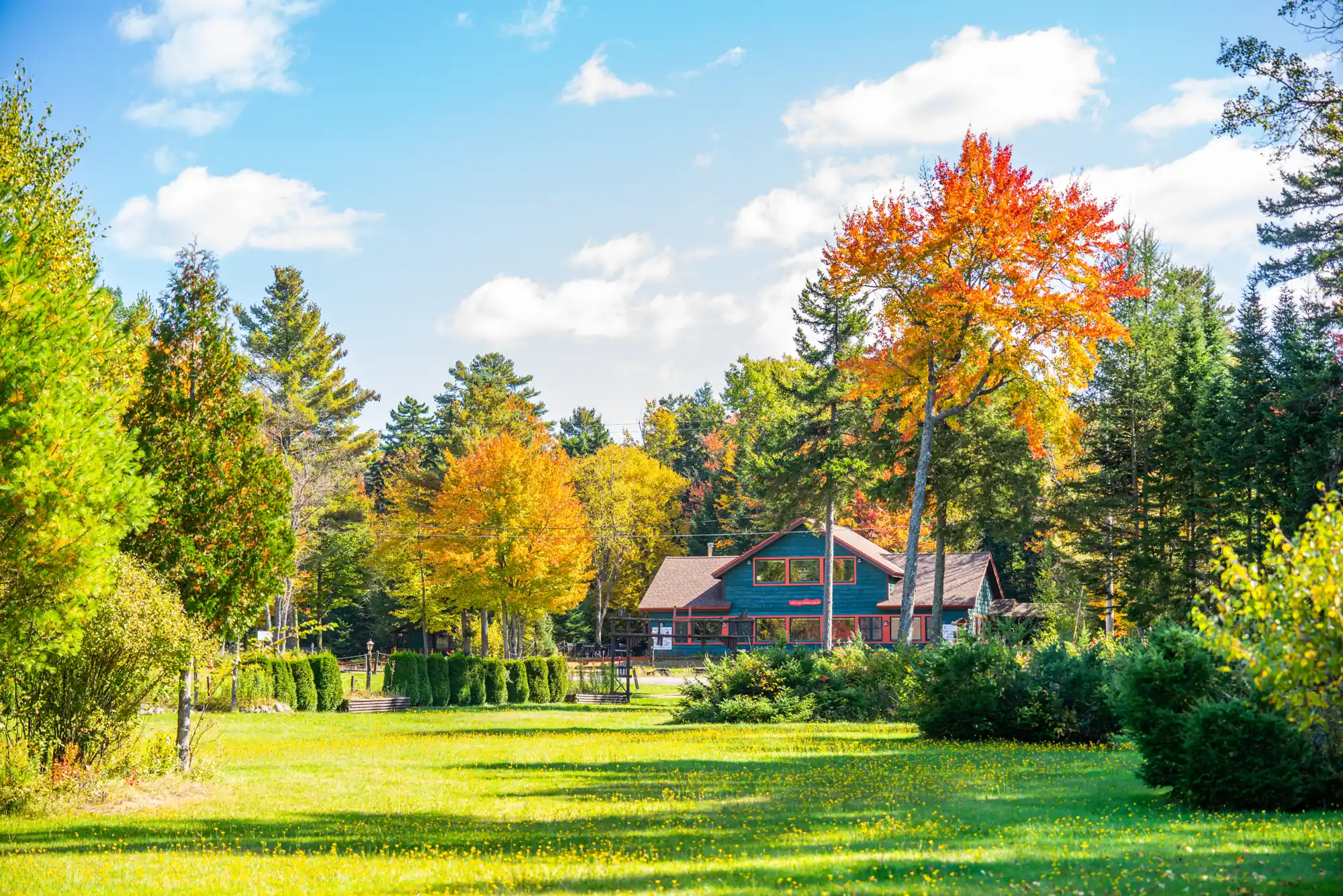 The colorful outdoor grounds of the Lake Clear Lodge during brilliant fall foliage.