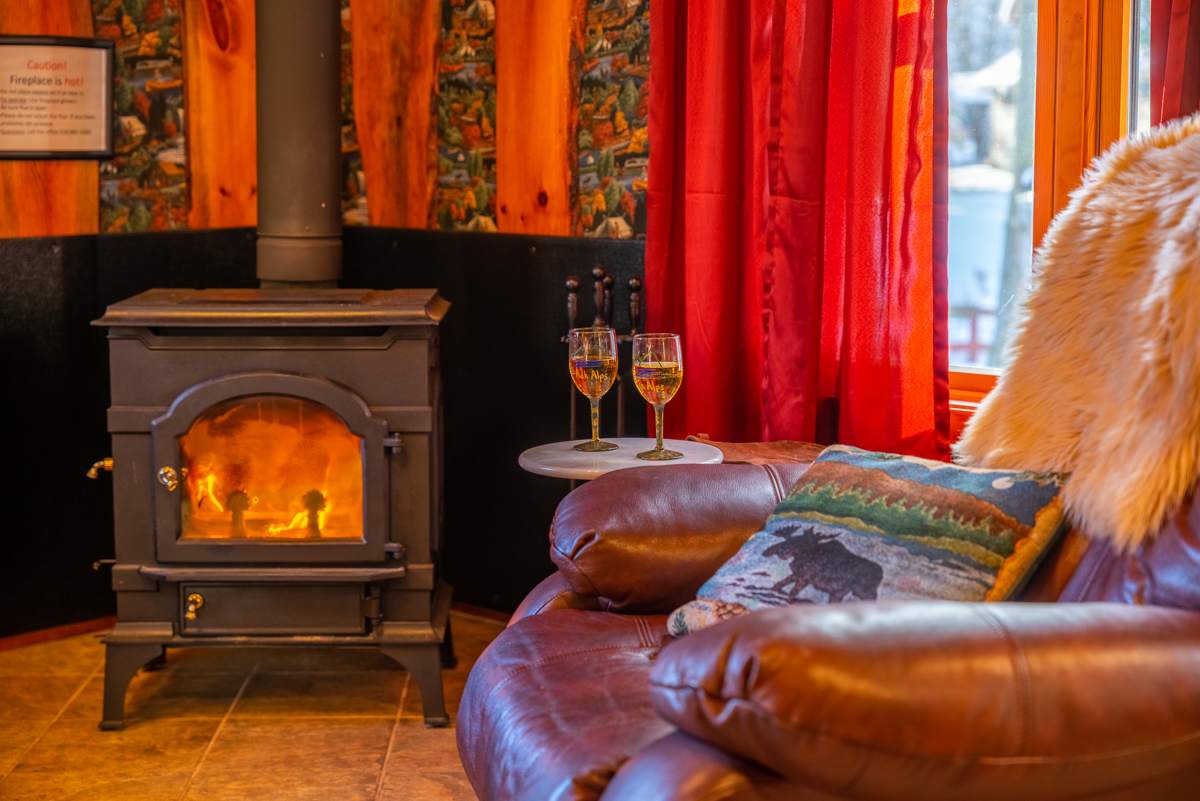 The Writer's Cabin living room with wood-burning fireplace and plush leather chair.