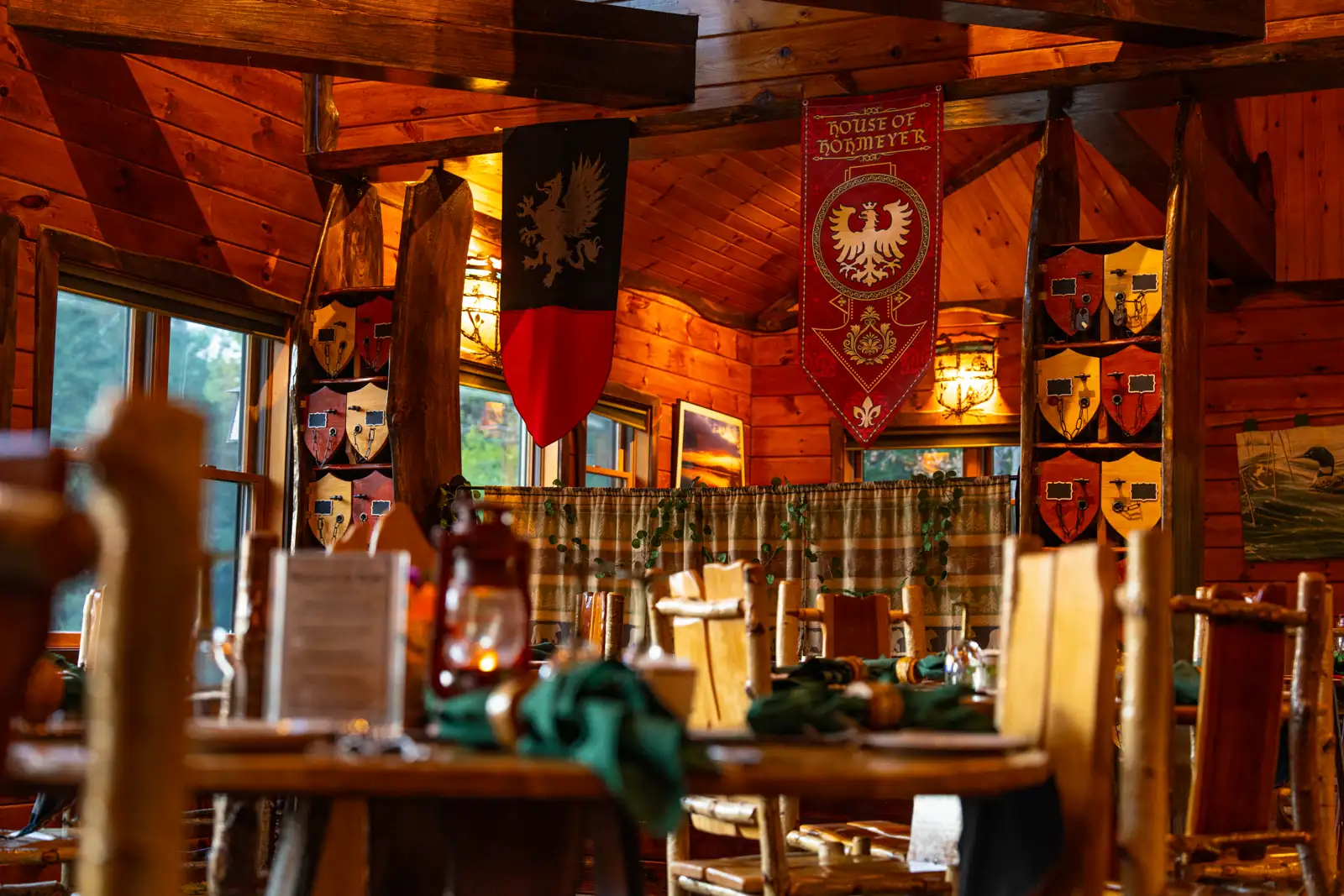 "House of Hohmeyer" banner hanging in front of a medieval fireplace at the Lake Clear Lodge lake view dining room.