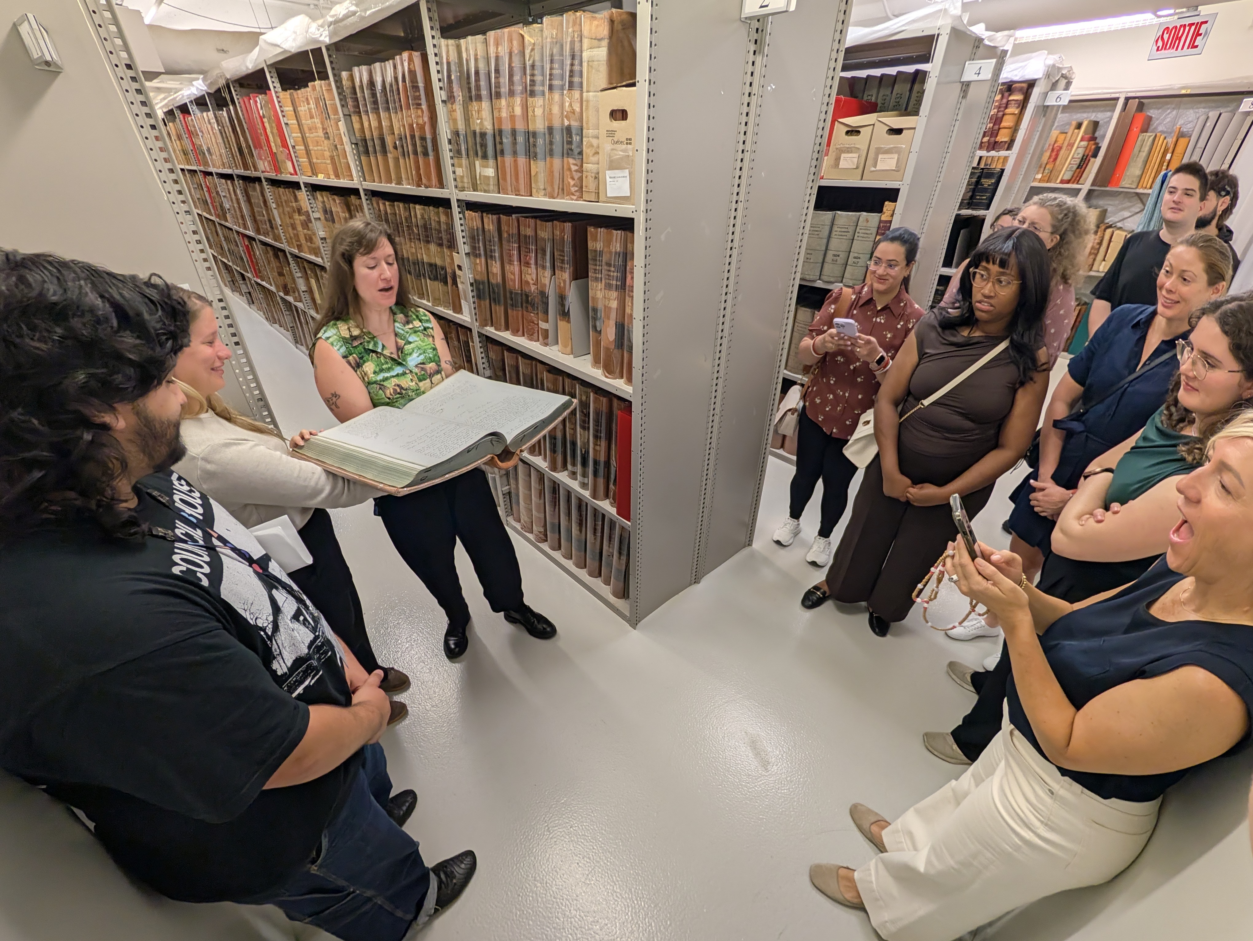 L'équipe de Marin Immigration Law dans les réserves de BAnQ à Montréal, pendant qu'un archiviste leur montre un registre historique