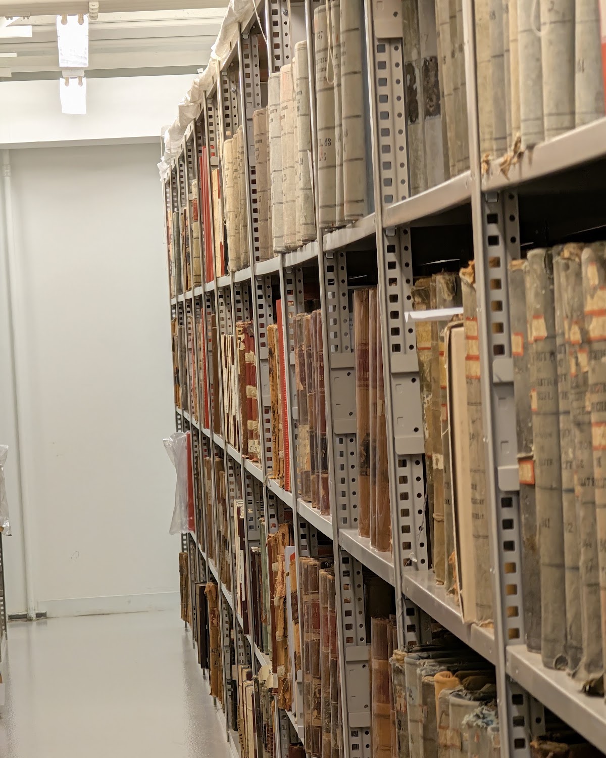 A long aisle of shelving filled with bound civil registers in the BAnQ storage vaults