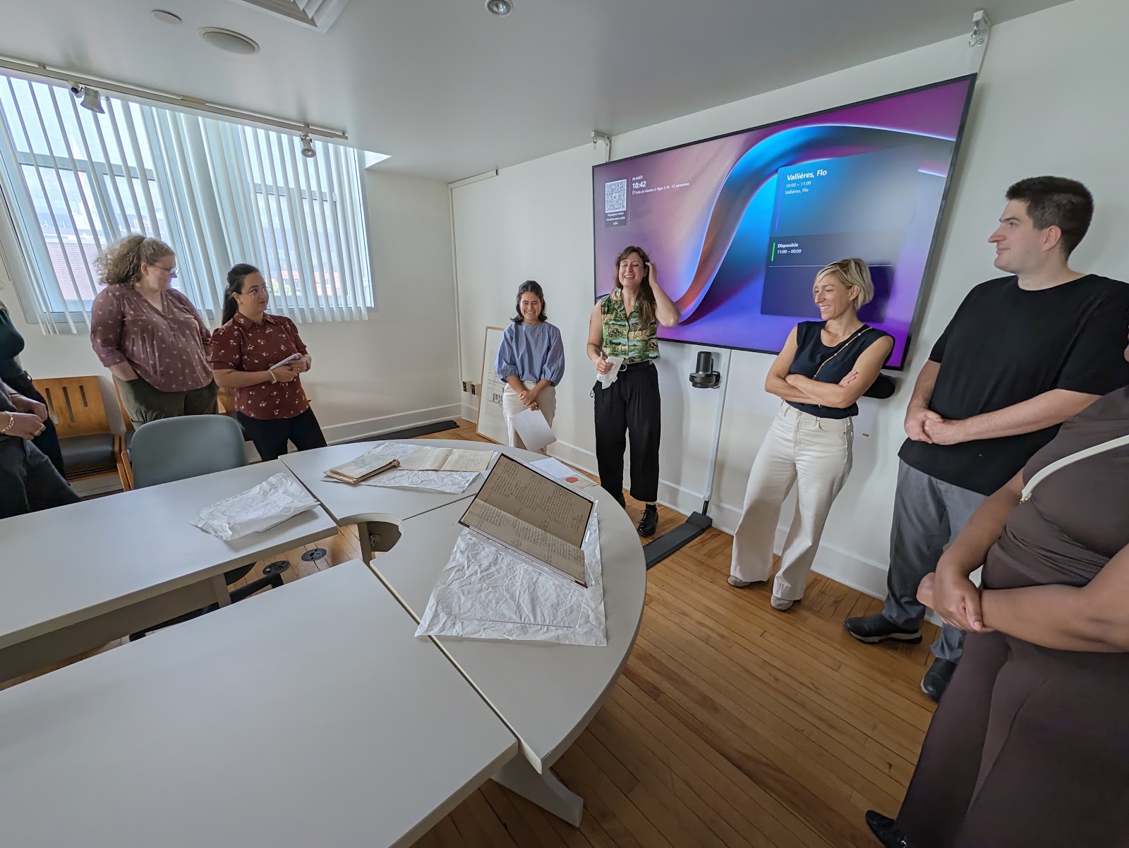 BAnQ staff present original documents to the Marin Immigration Law team in a meeting room