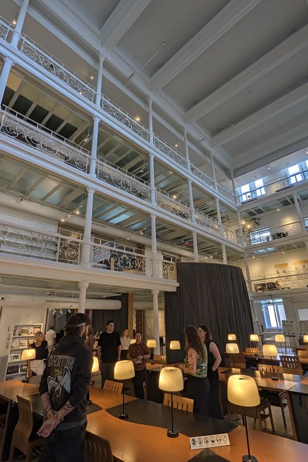 Visitors touring the BAnQ reading room in Old Montréal, with its cast-iron balconies and reading lamps