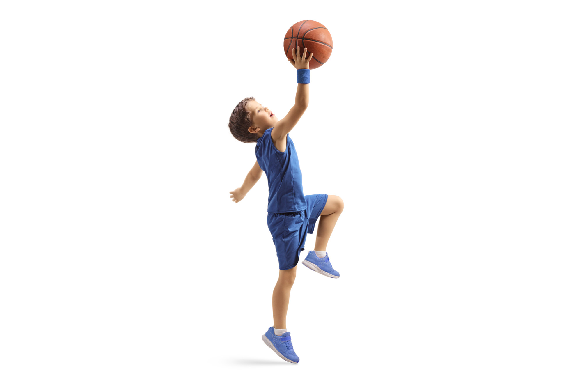 Kleiner Junge, der einen Basketball in der Hand hält und zum Wurf ansetzt