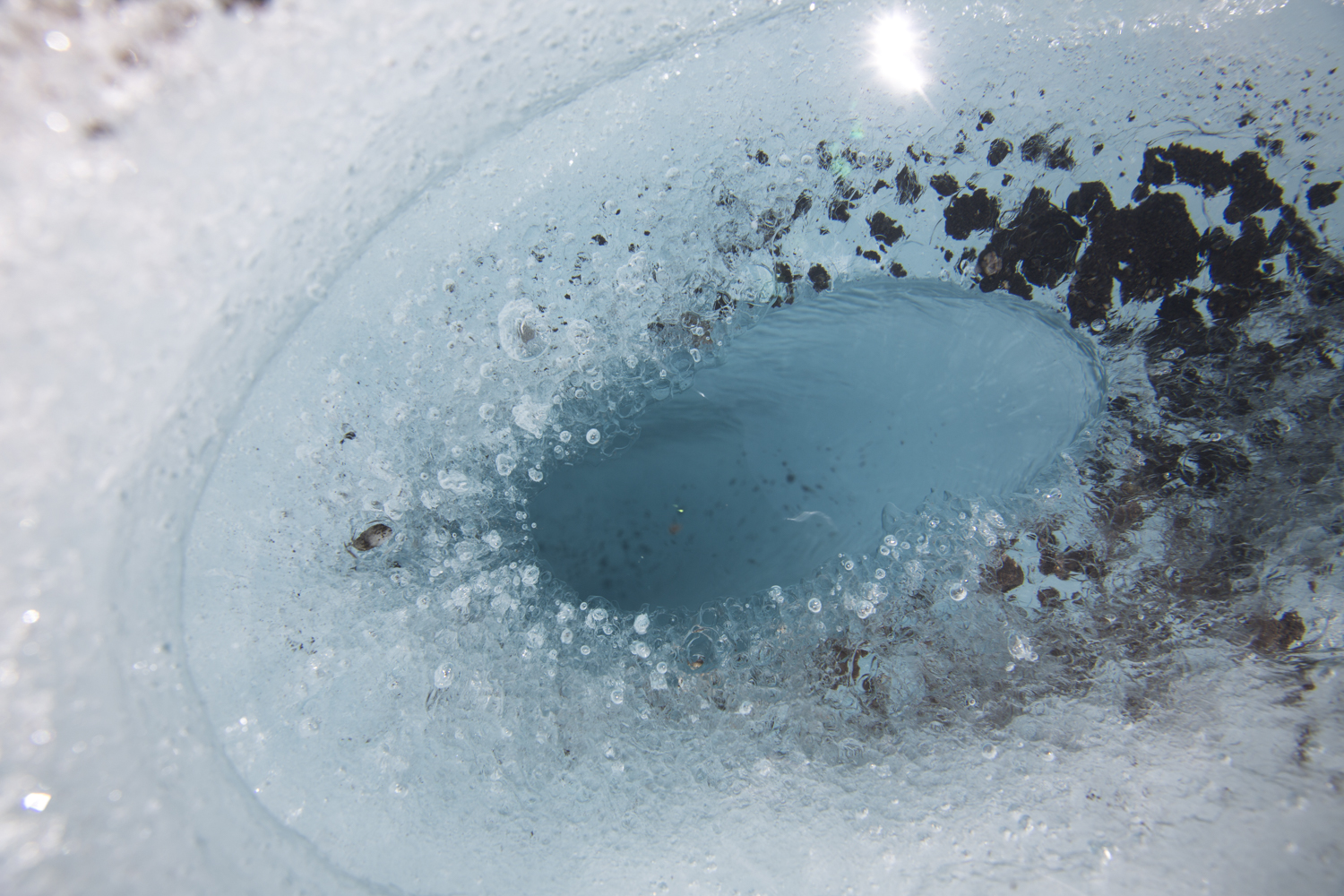 Formation circulaire dans la glace avec centre fondu, motif concentrique naturel EN : Circular ice formation with melted center, natural concentric pattern
