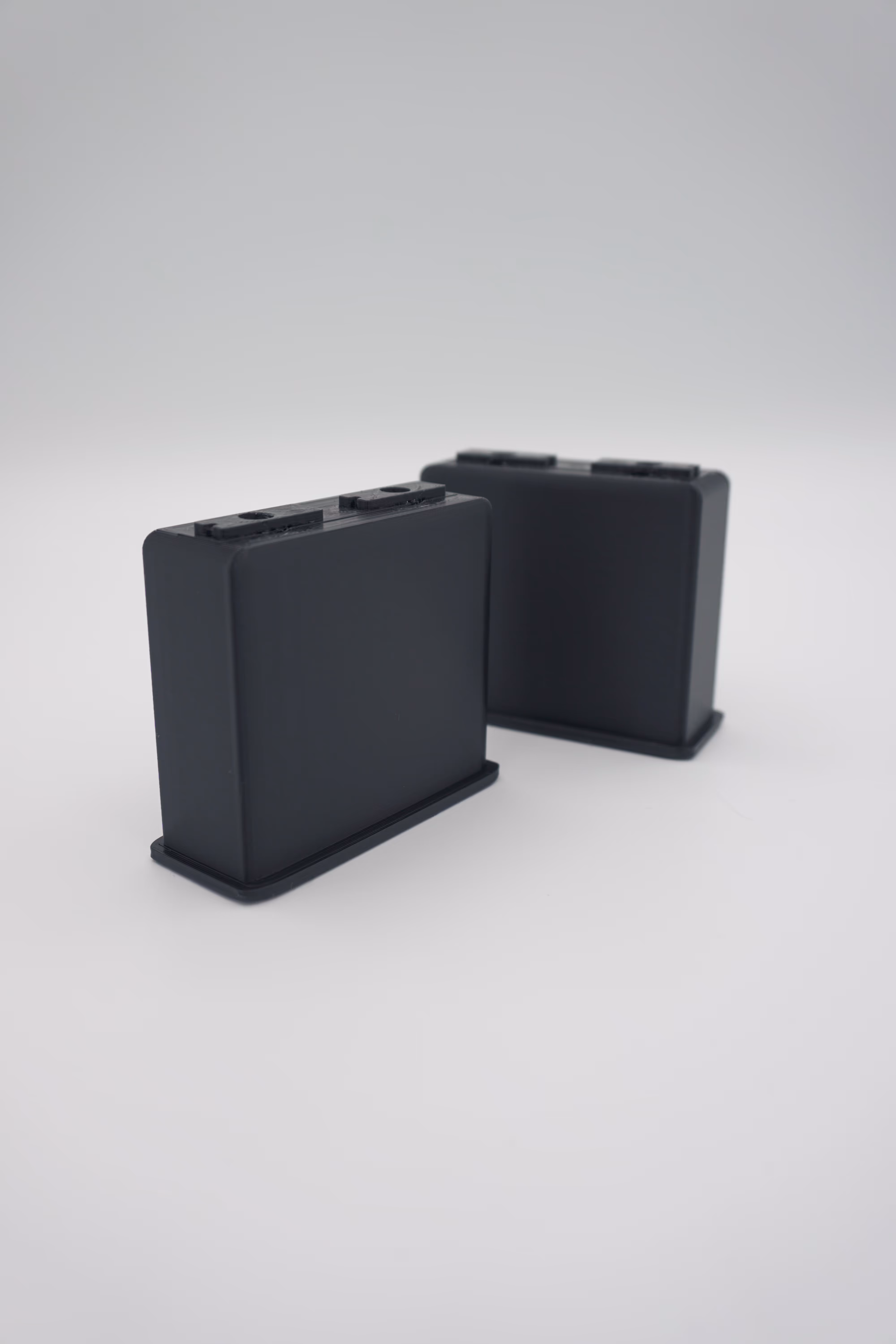 Twee zwarte 3D-geprinte poten voor een bureauverhoger